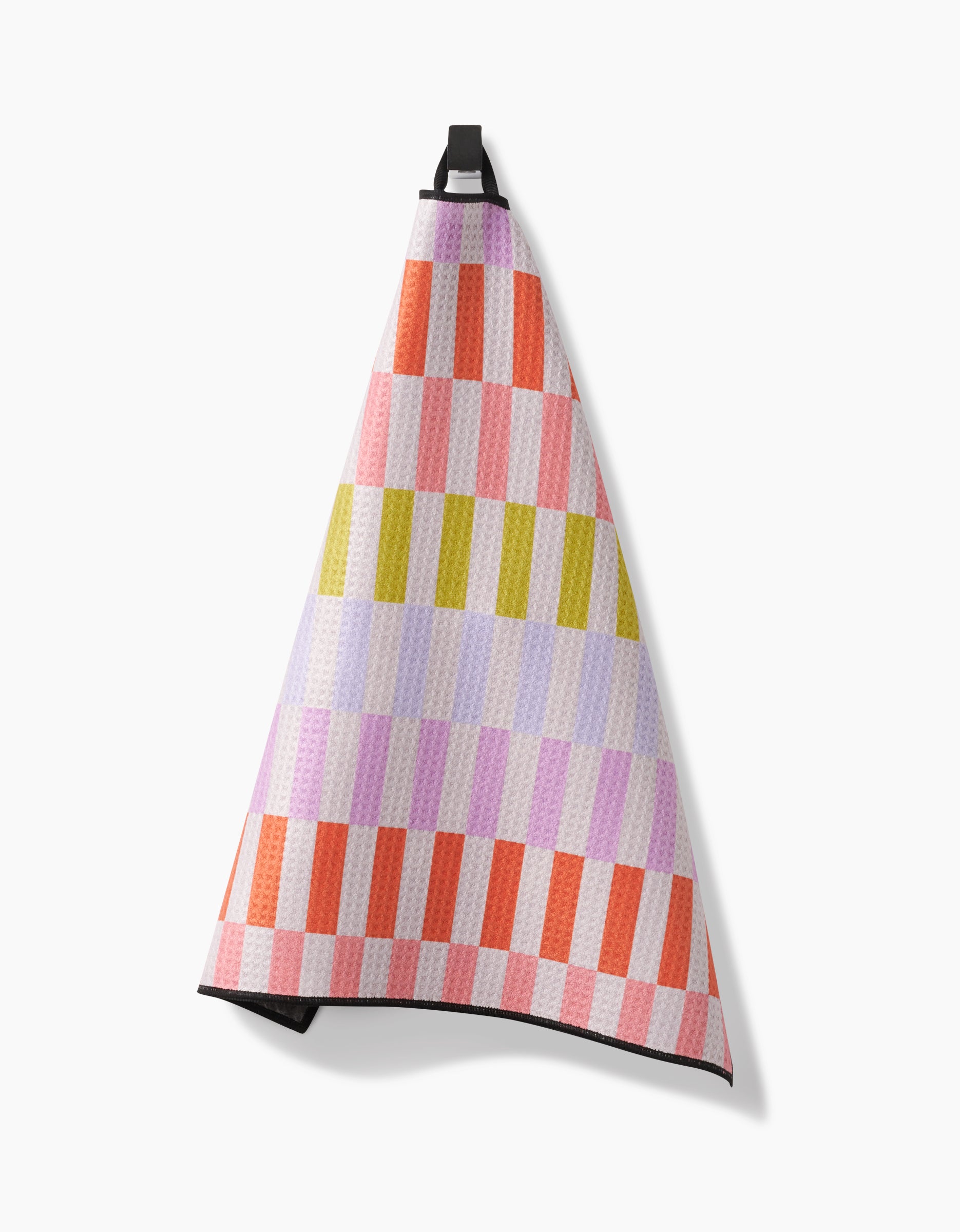 The Wag Wise Paw Towel by Geometry hangs from a hook, showcasing a checkered pattern in pink, red, lavender, yellow, and white on a light background. Its ultra-absorbent Geoweave fabric ensures exceptional drying power.