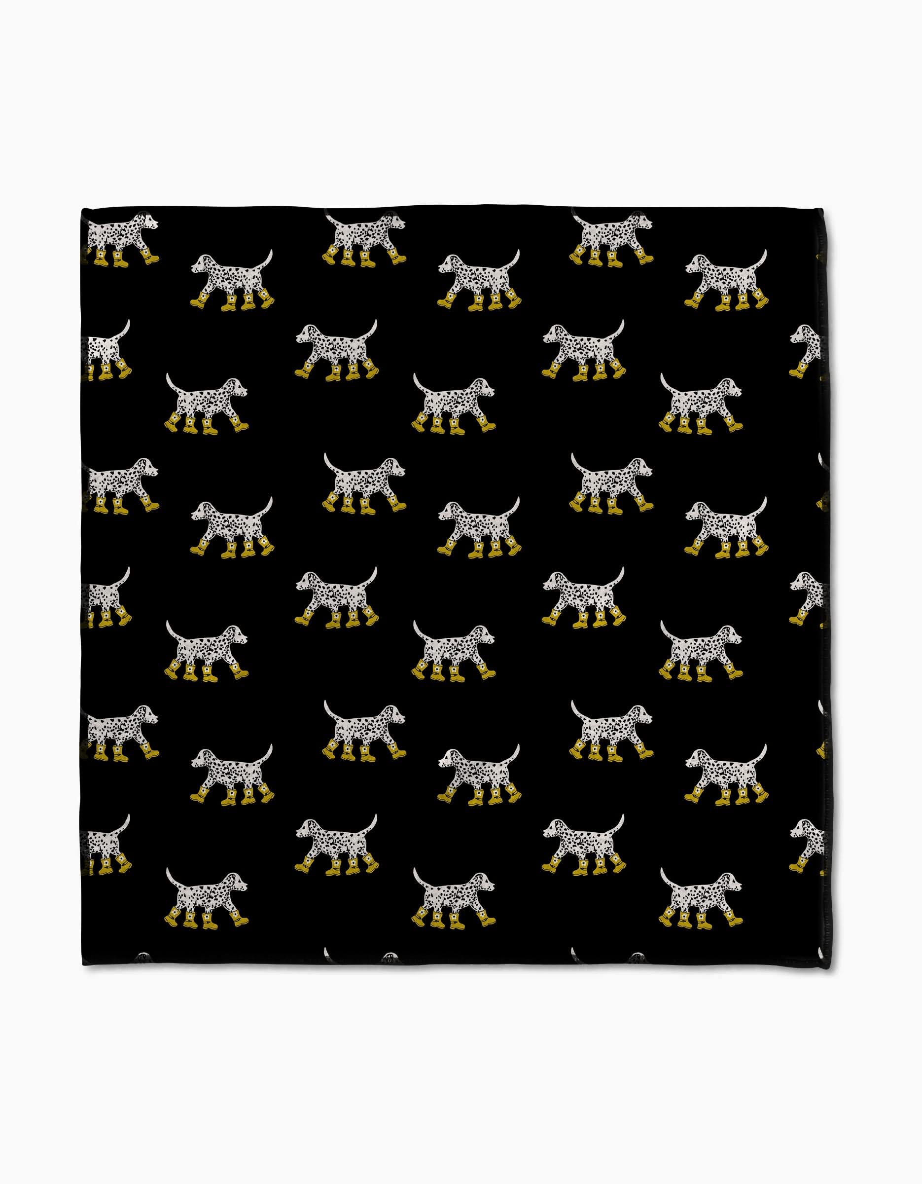 Dalmatian In Boots Black by Geometry features rows of spotted dogs in yellow rain boots on a black background. Printed on ultra-absorbent Geoweave fabric, this Paw Towel blends playful style with practical functionality.