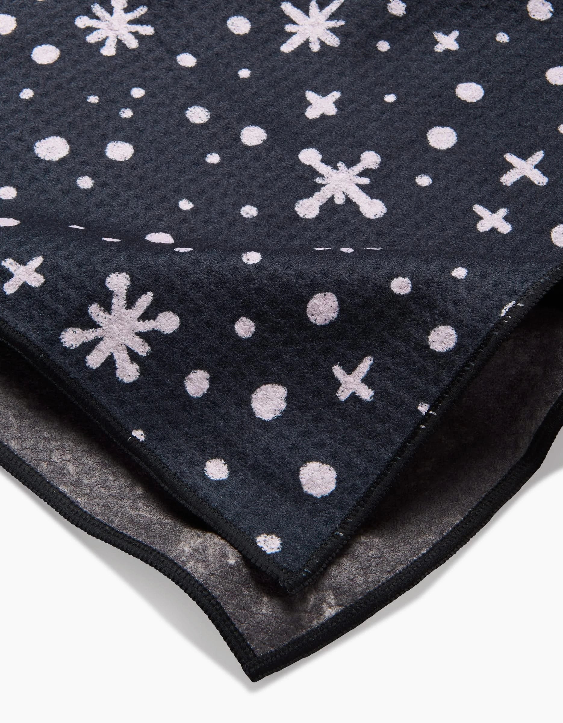 A close-up of the Estrella fleece blanket by Amy MacCready, featuring white snowflakes and dots with a plush underside—perfect as an ultra-absorbent dog towel or cozy Paw Towel.