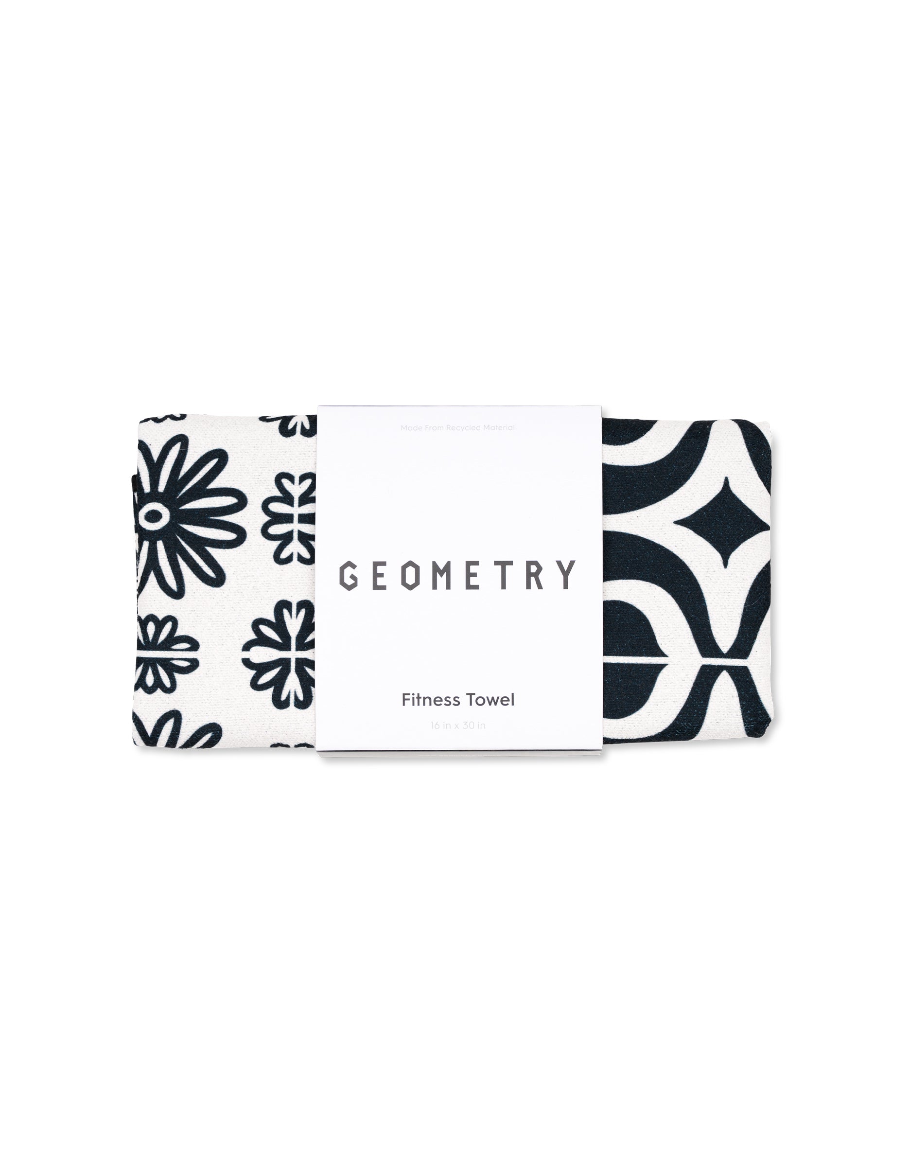 A black and white ultra-absorbent GEOMETRY fitness towel, folded and wrapped with a label, featuring geometric and floral patterns. Product name: Magna - Bohemian Mosaic.