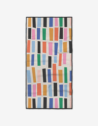 The Bricks fitness towel by Jennifer Bouron features colorful vertical rectangles on a light beige background. Ultra-absorbent and made from recycled materials, its perfect for everyday use.