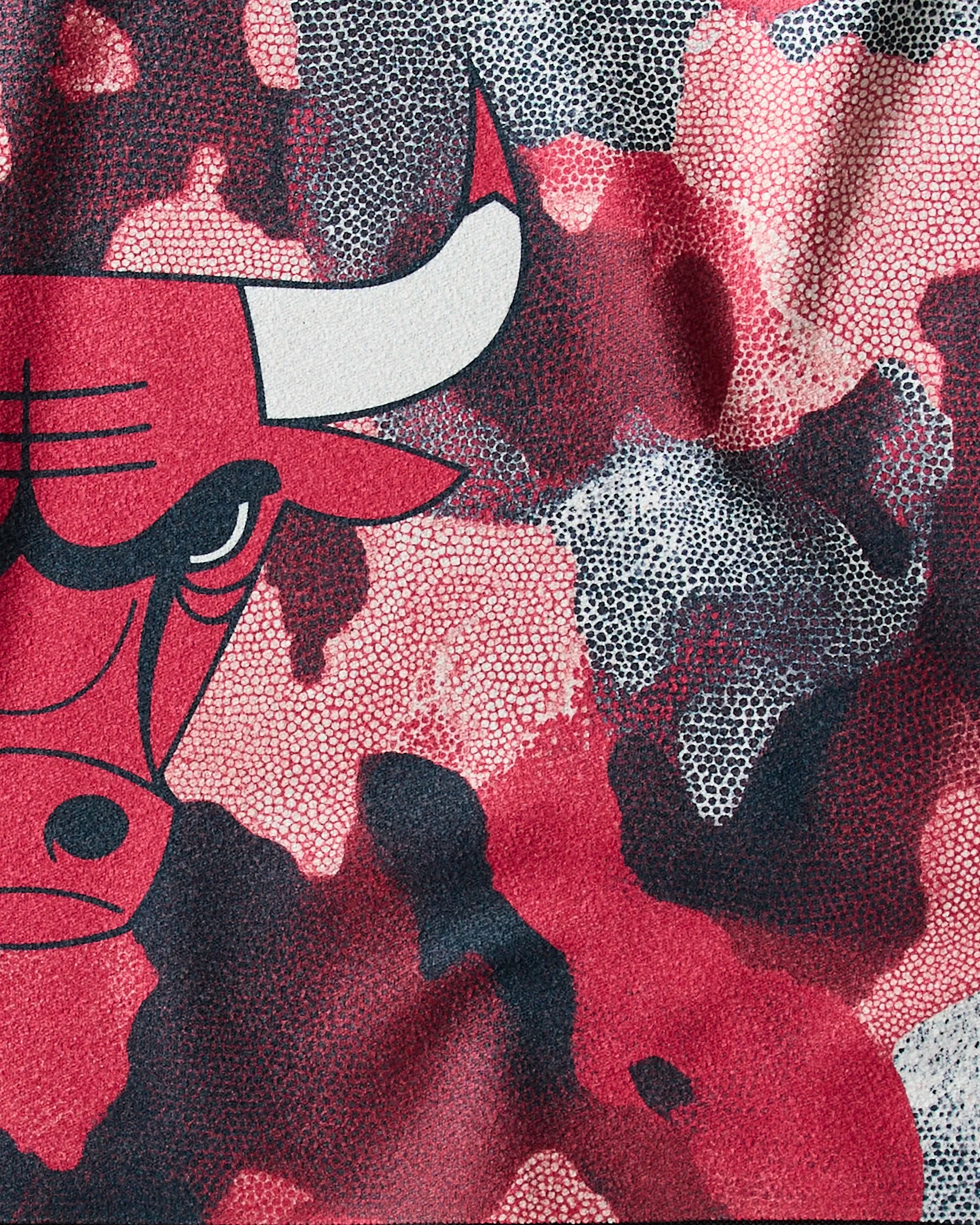 Close-up of the Bulls Camo fabric by Geometry, showcasing the Chicago Bulls logo with a partial red bull face on the left over a red, black, and white camo pattern.