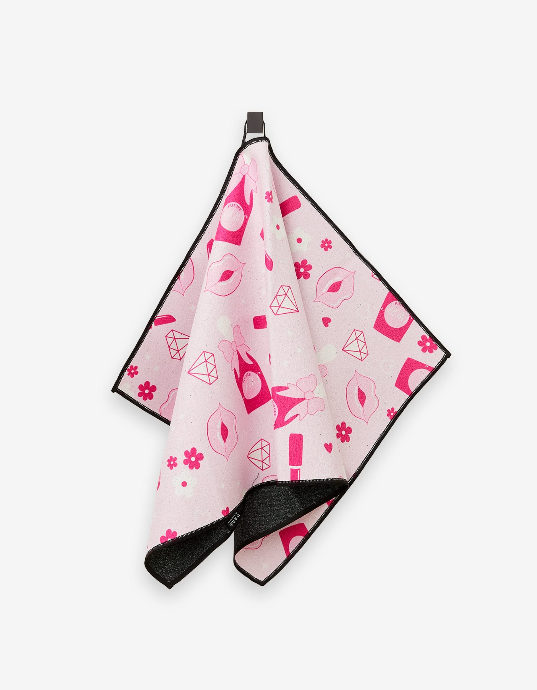 The GEOMETRY Cheers towel, ultra-absorbent and fun, hangs on a hook with black edges and playful pink patterns—lips, diamonds, nail polish, perfume bottles, flowers, and hearts.