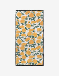 The Chrysanthemum fitness towel by Vaishali Design Studio features a vibrant yellow chrysanthemum and green leaf pattern on white, edged in black, and is made from ultra-absorbent Geoweave fabric.