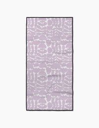 The Katie OShea Lavender Scandi Flowers towel features a rectangular, ultra-absorbent design with a light purple and white abstract botanical pattern and a slim black border, shown flat on a white background.