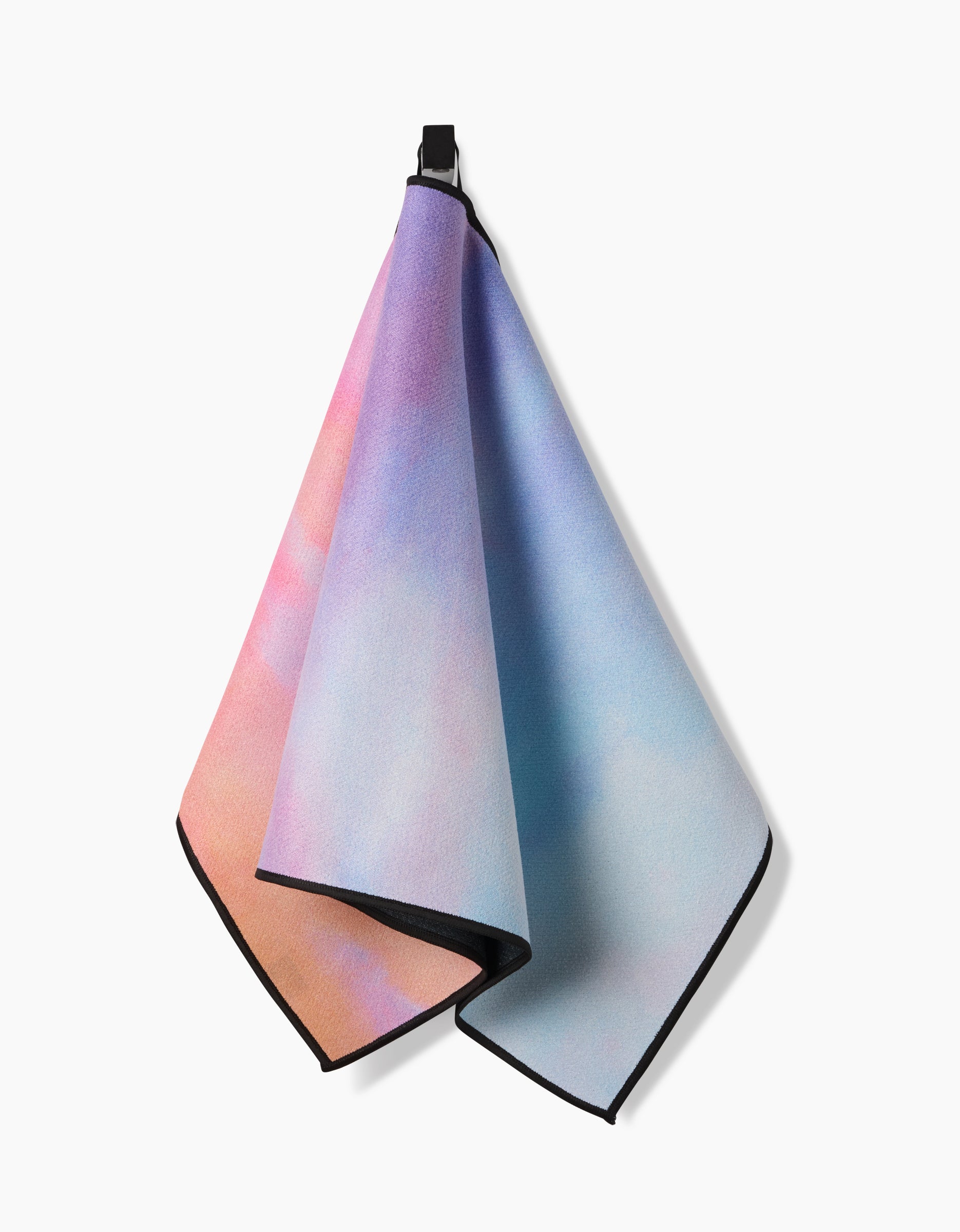 The Stefanie Bales Magic In The Sky towel features a pastel pink, purple, and blue gradient with black trim and a black hanging loop, shown against a white background.