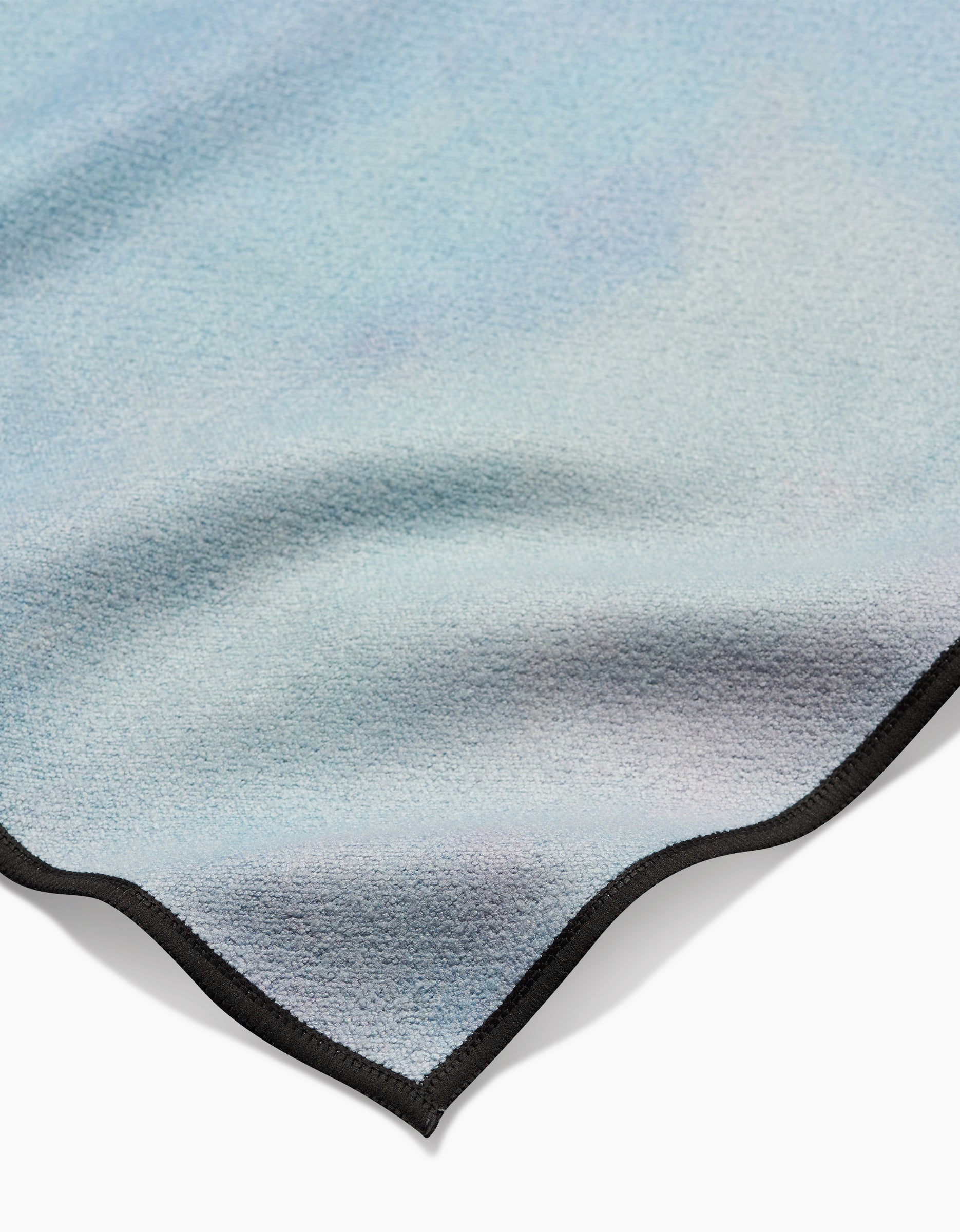 A close-up of the Magic In The Sky fleece blanket by Stefanie Bales, featuring a soft light blue gradient, black trimmed edges, and ultra-absorbent Geoweave fabric, displayed on a white background.