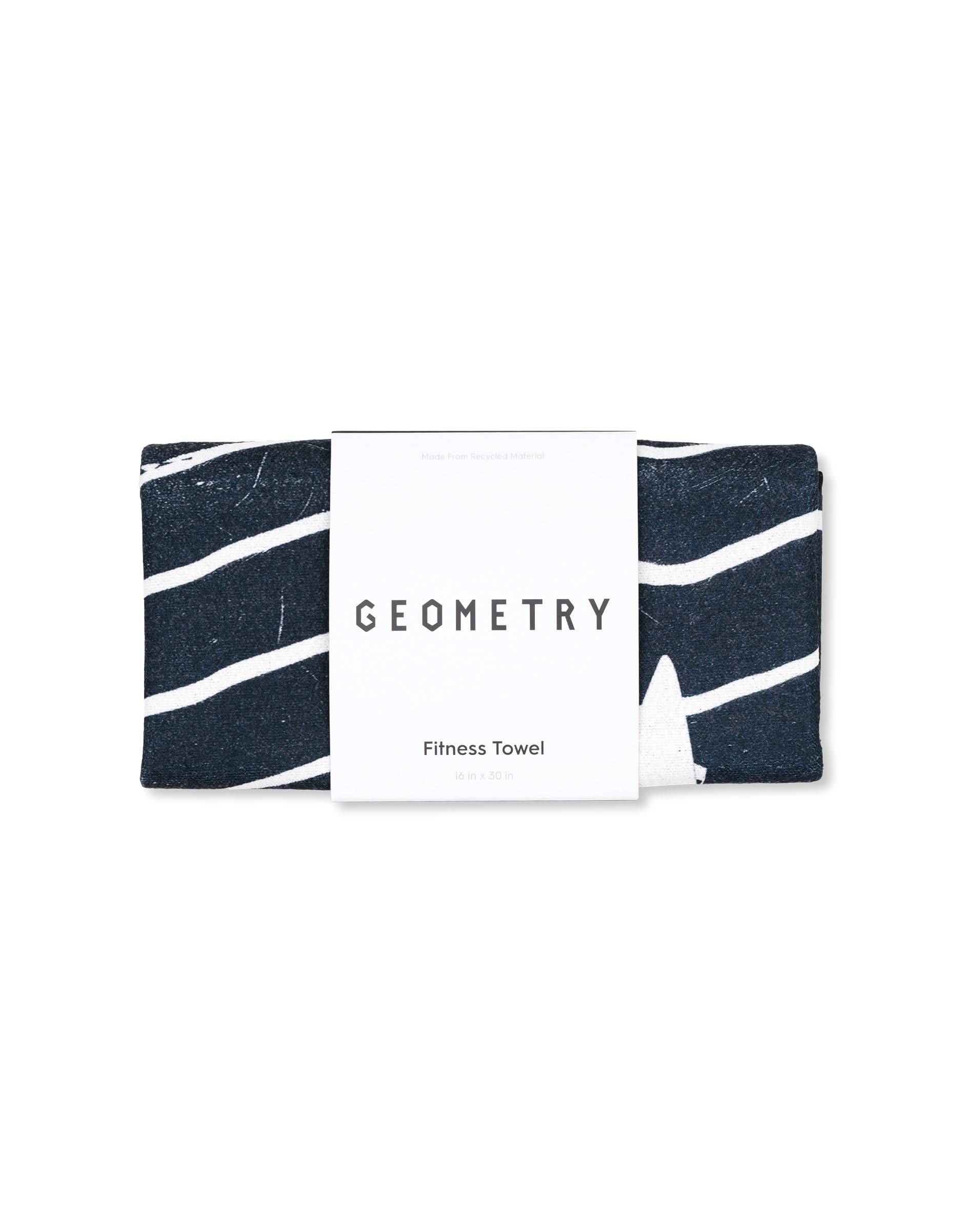 A dark blue recycled gym towel with white wavy lines, partially wrapped in a white label reading GEOMETRY Magna - Ting 16 in x 30 in.