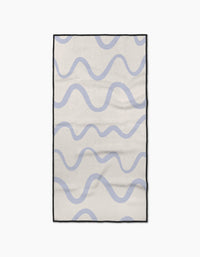 The Wavy Stripe in Blue rug by Teri the Butter features a cream base with light blue wavy stripes, a black border, and a simple, modern look. Made from ultra-absorbent materials for quick drying after spills or cleaning.