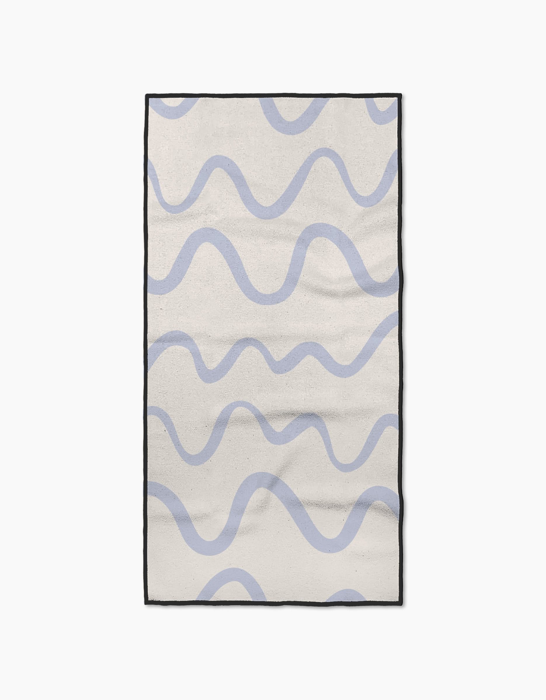The Wavy Stripe in Blue rug by Teri the Butter features a cream base with light blue wavy stripes, a black border, and a simple, modern look. Made from ultra-absorbent materials for quick drying after spills or cleaning.