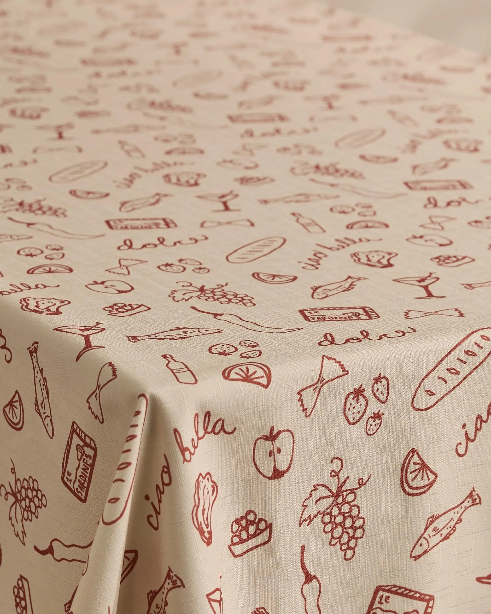 The Geometry Summer Air tablecloth features a beige, stain-resistant design with red line art of Italian foods and handwritten phrases like ciao bella. Made from recycled materials, its ideal for any kitchen or dining space.