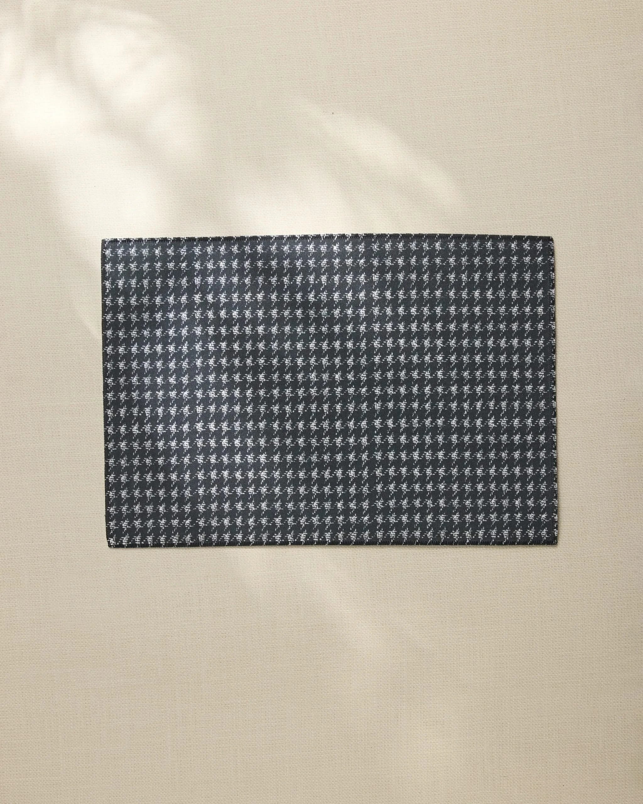 The Houndstooth Black by Geometry is a chic, rectangular black fabric with a white houndstooth pattern—machine washable and perfect as everyday placemats.