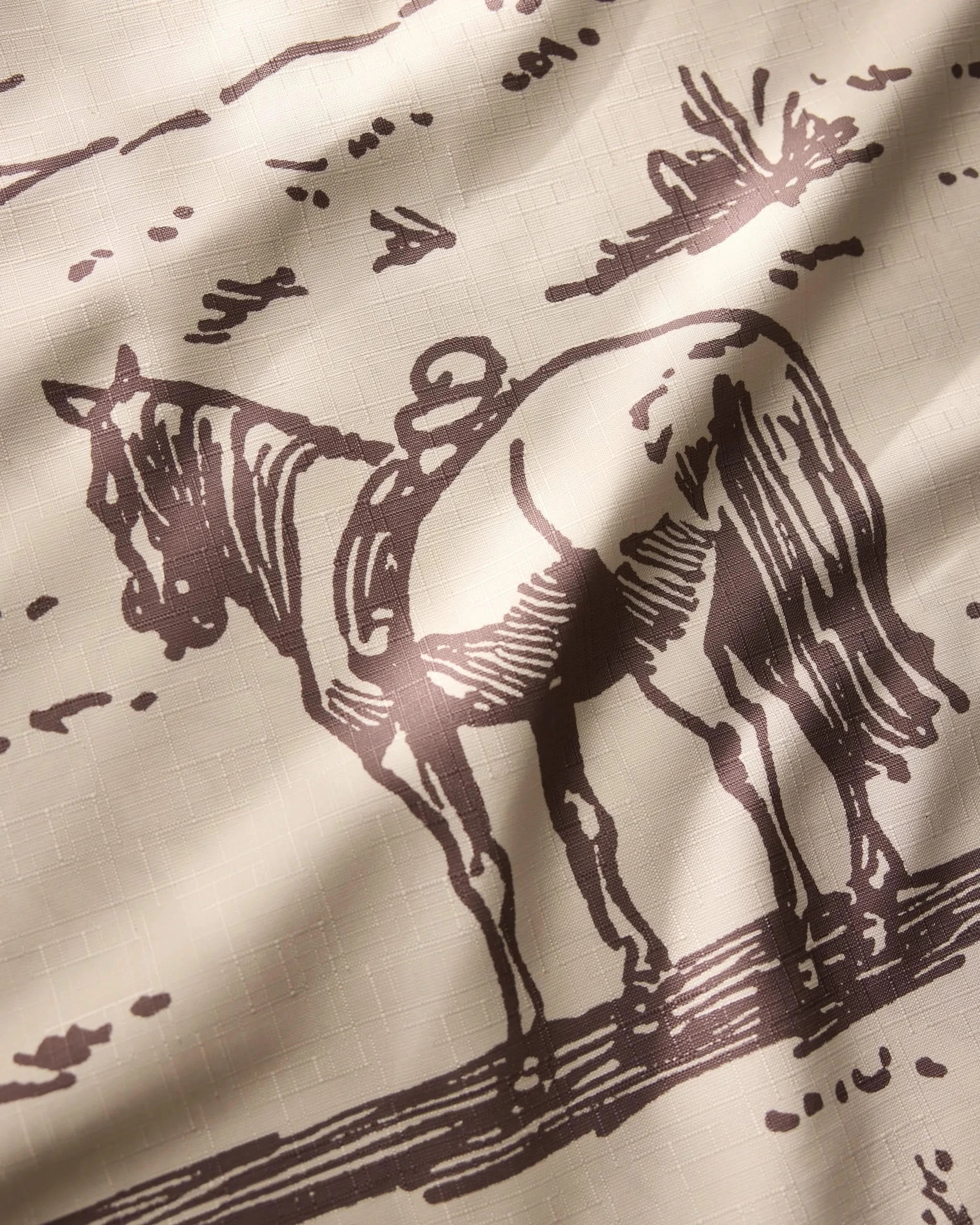 The Geometry Western Scene tablecloth is lightweight and features a sepia illustration of a saddled horse outdoors, with gentle shadows and soft folds enhancing the fabrics depth.