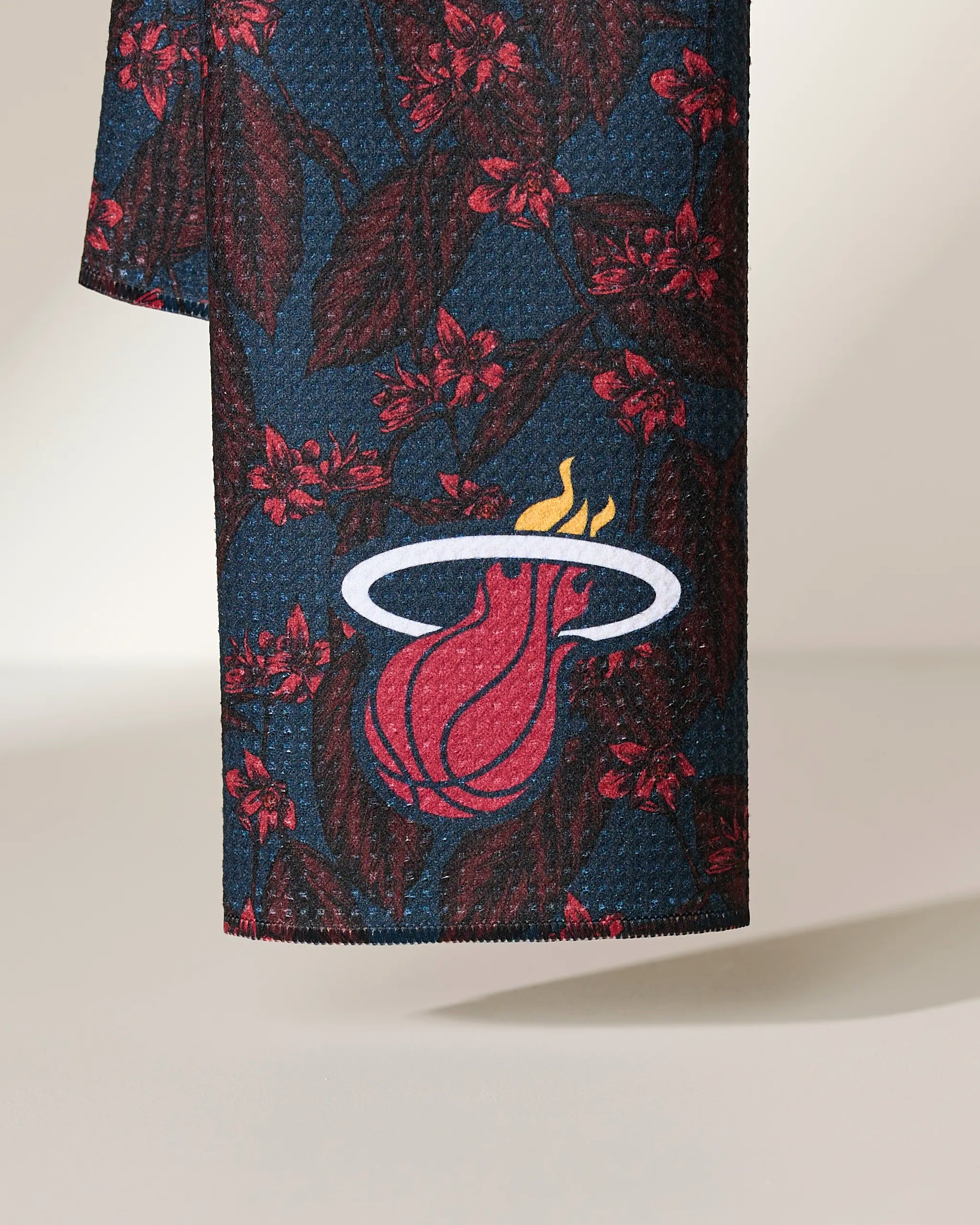 Geometry’s Heat Floral features a dark blue fabric with red floral designs and the Miami Heat logo—a flaming basketball passing through a white hoop.