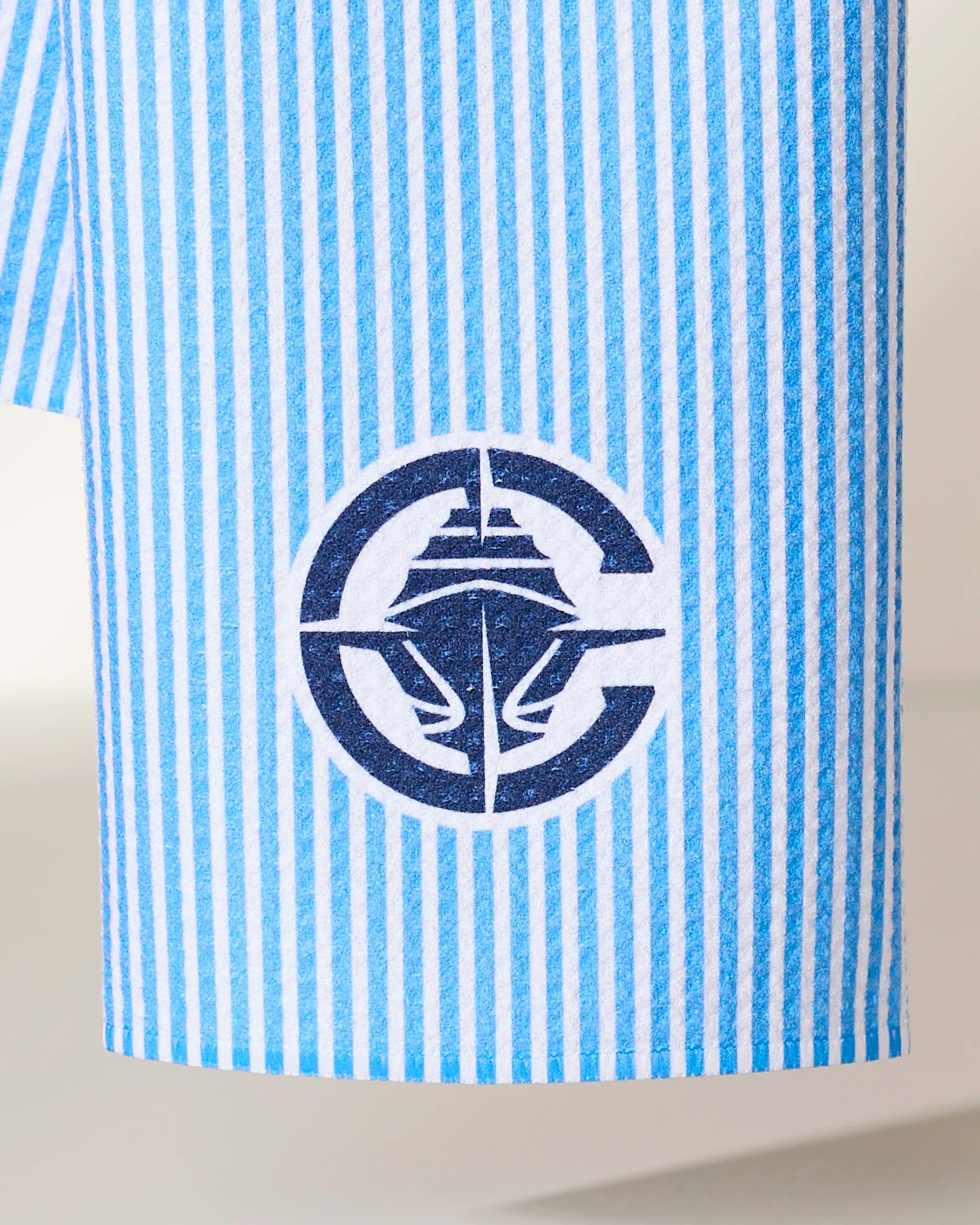 The Clippers Classic by Geometry features a blue and white vertical striped fabric with a navy circular logo displaying a stylized cruise ship at its center.