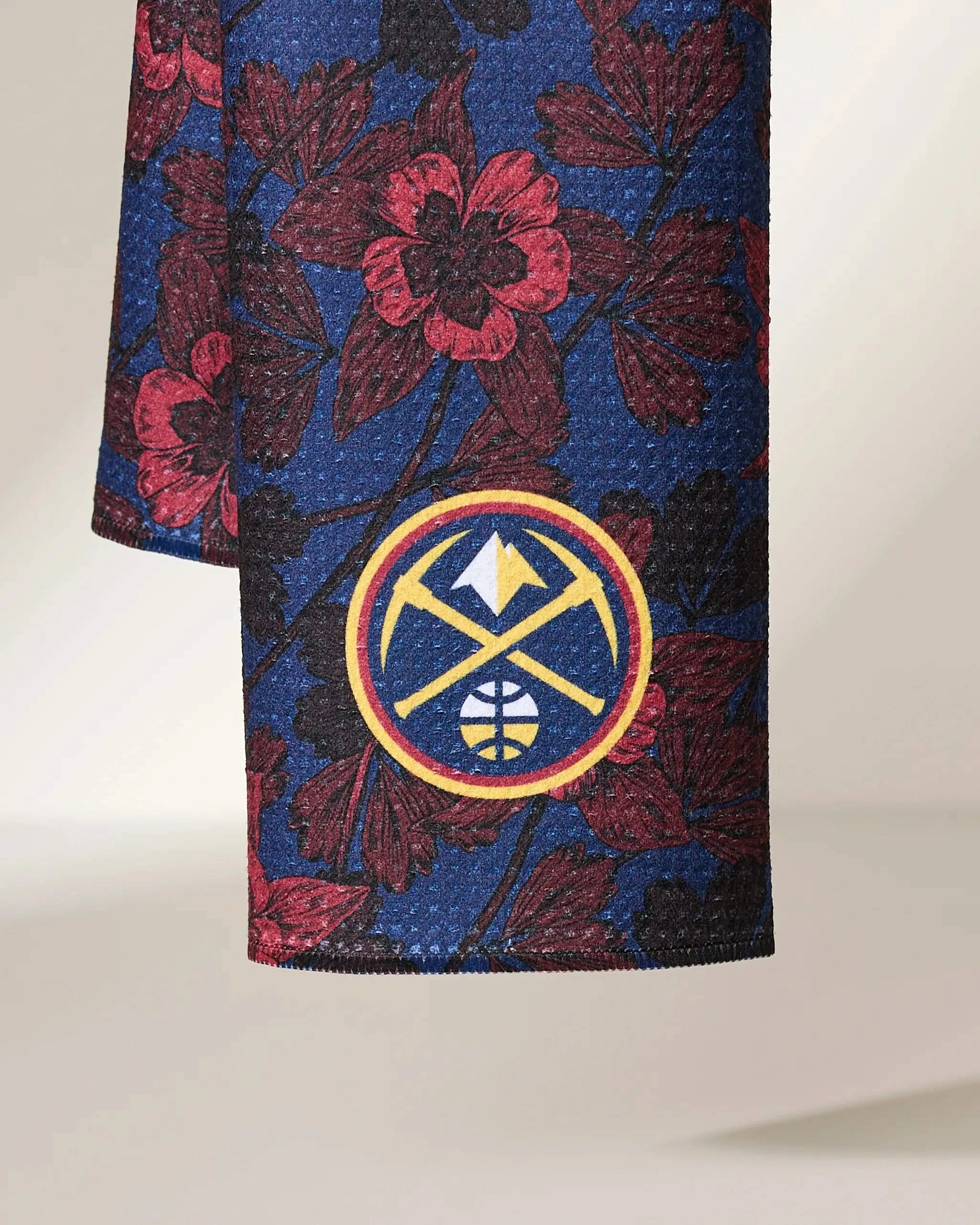 Geometry’s Nuggets Floral features a blue fabric with a red floral pattern and the Denver Nuggets yellow mountain and basketball logo near the bottom edge.