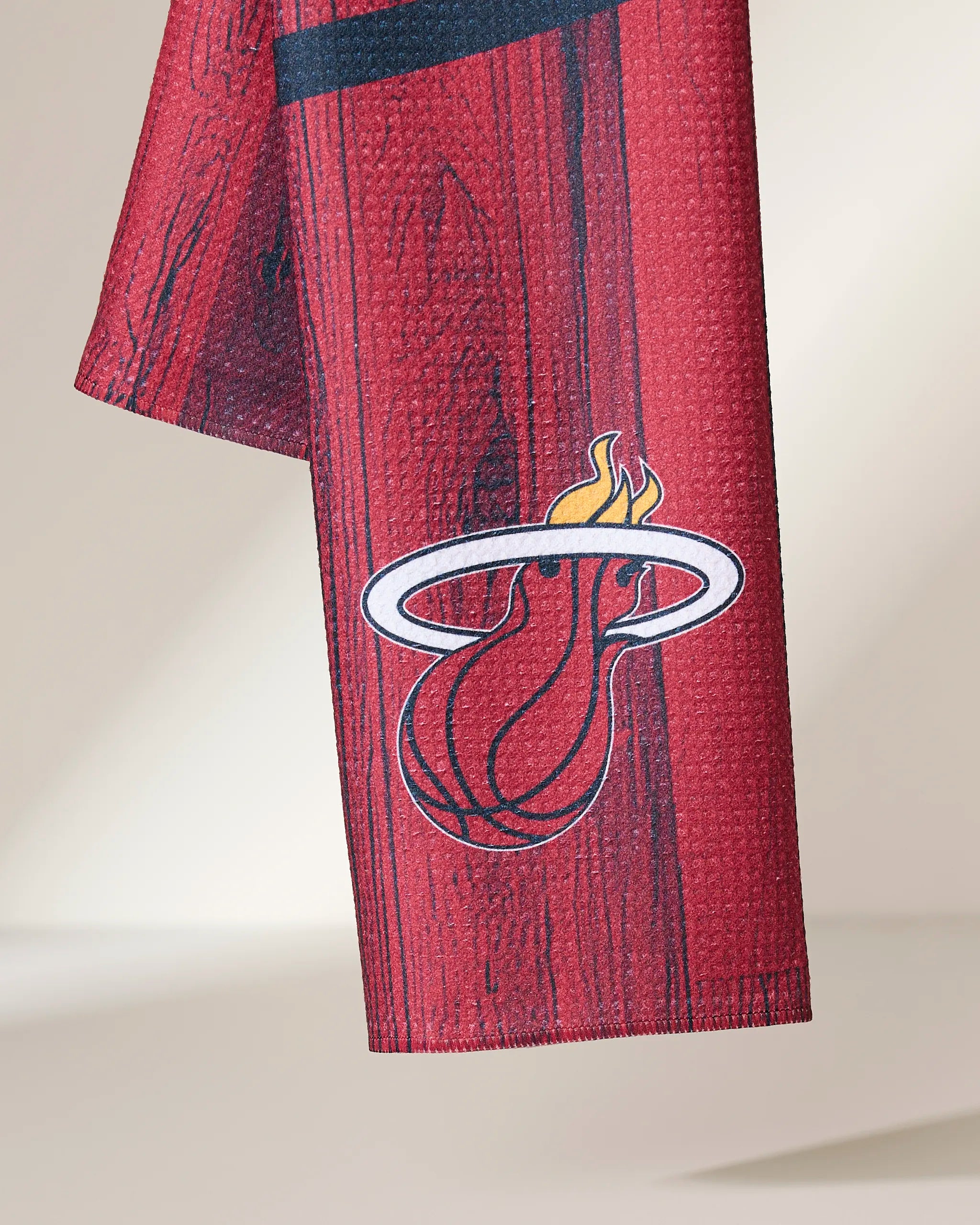 A close-up of the Geometry Heat Zone red basketball jersey with a woodgrain pattern and the Miami Heat logo, showing a flaming basketball through a white hoop near the bottom edge.