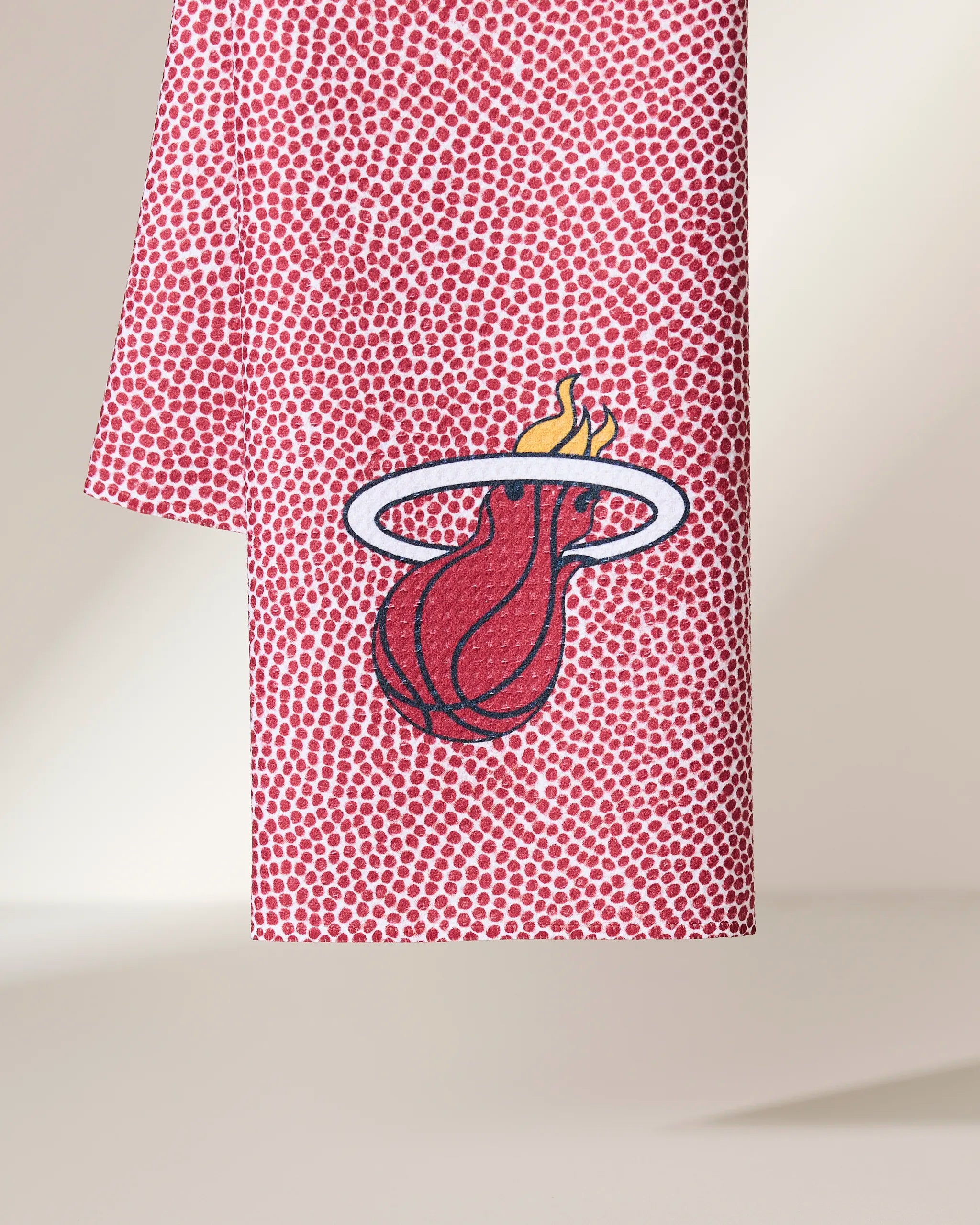 The Geometry Heat Grip towel features a red dotted pattern like a basketball and showcases the Miami Heat logo—a flaming basketball through a white hoop—at the center.