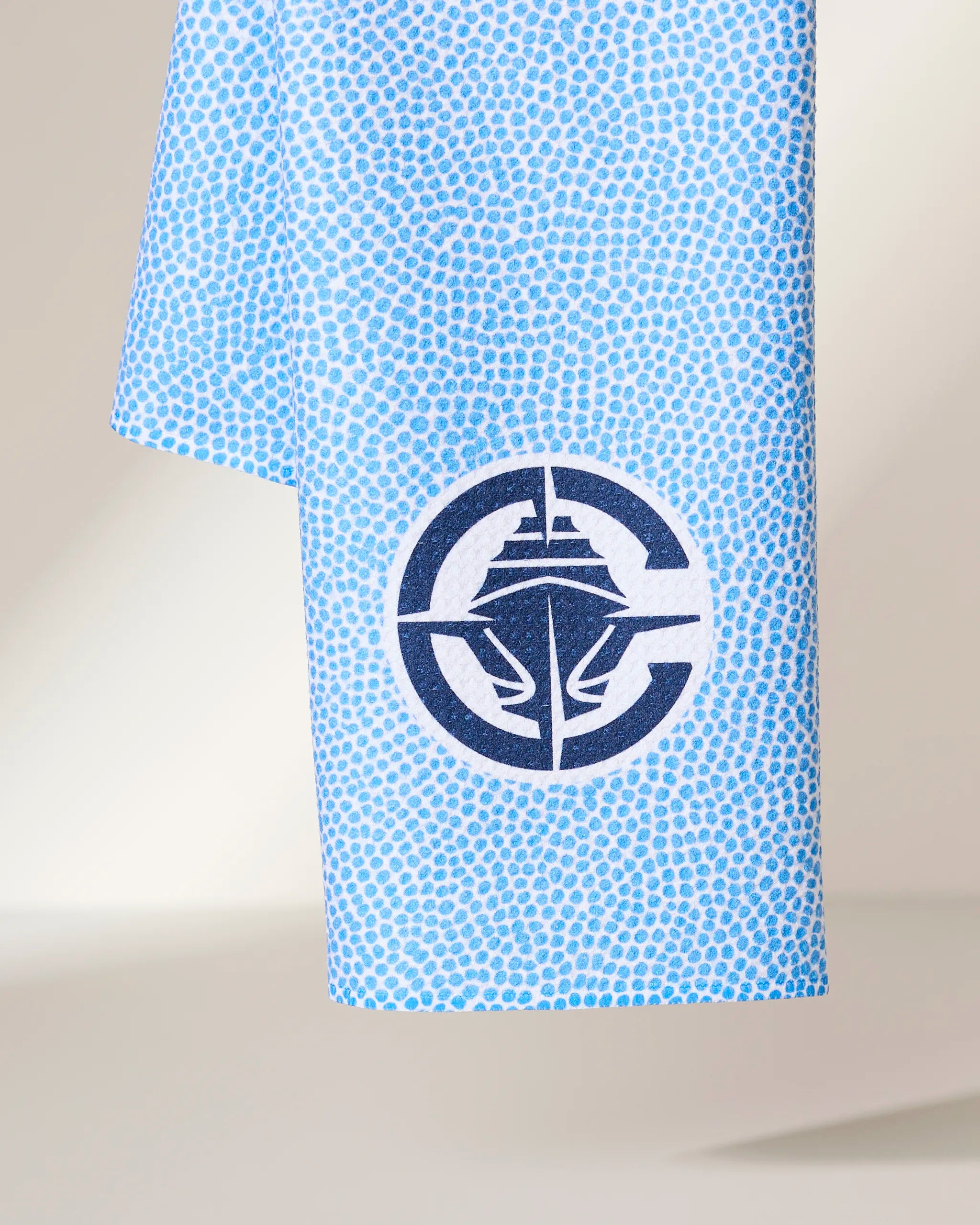The Geometry Clippers Grip towel features a light blue design with small, scattered darker blue dots and a navy circular logo with a stylized ship at the center.