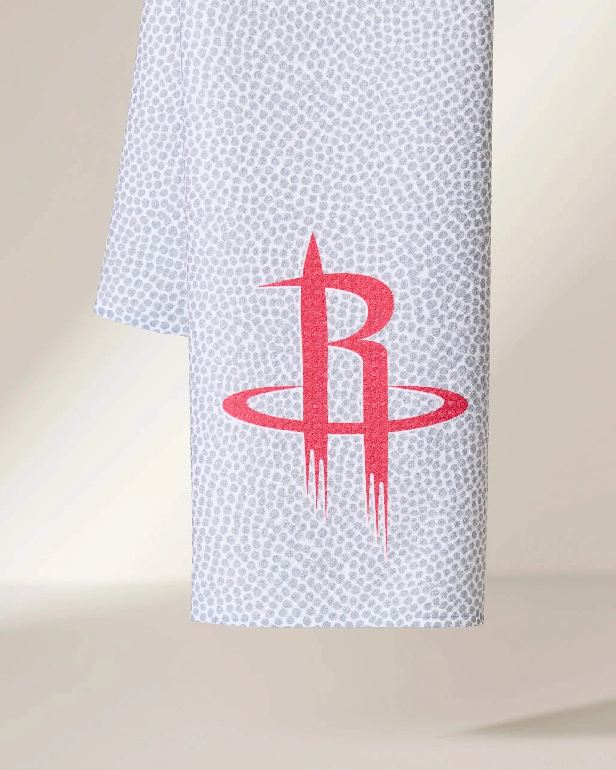The Geometry Rockets Grip is a white towel with a subtle gray dotted pattern and a large red Houston Rockets logo in the center.