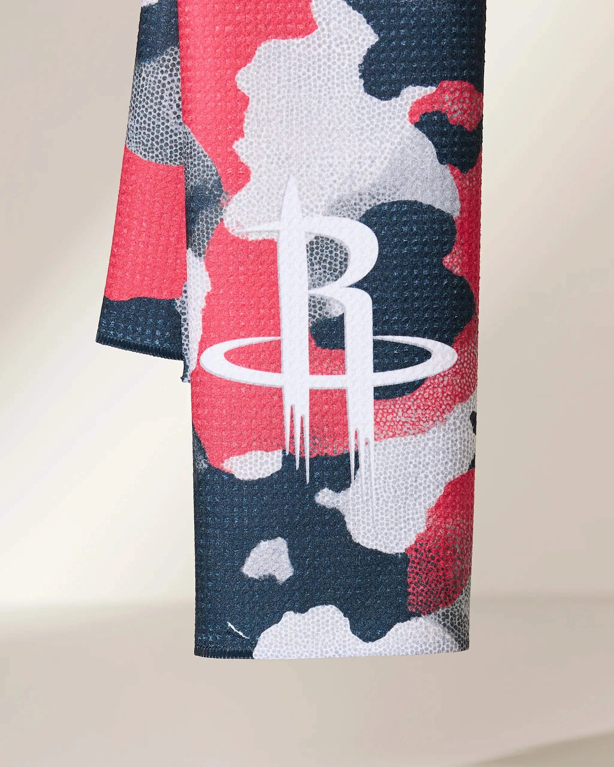 A close-up of the Geometry Rockets Camo fabric shows a red, white, and dark blue camouflage pattern with the Houston Rockets basketball team logo in white.