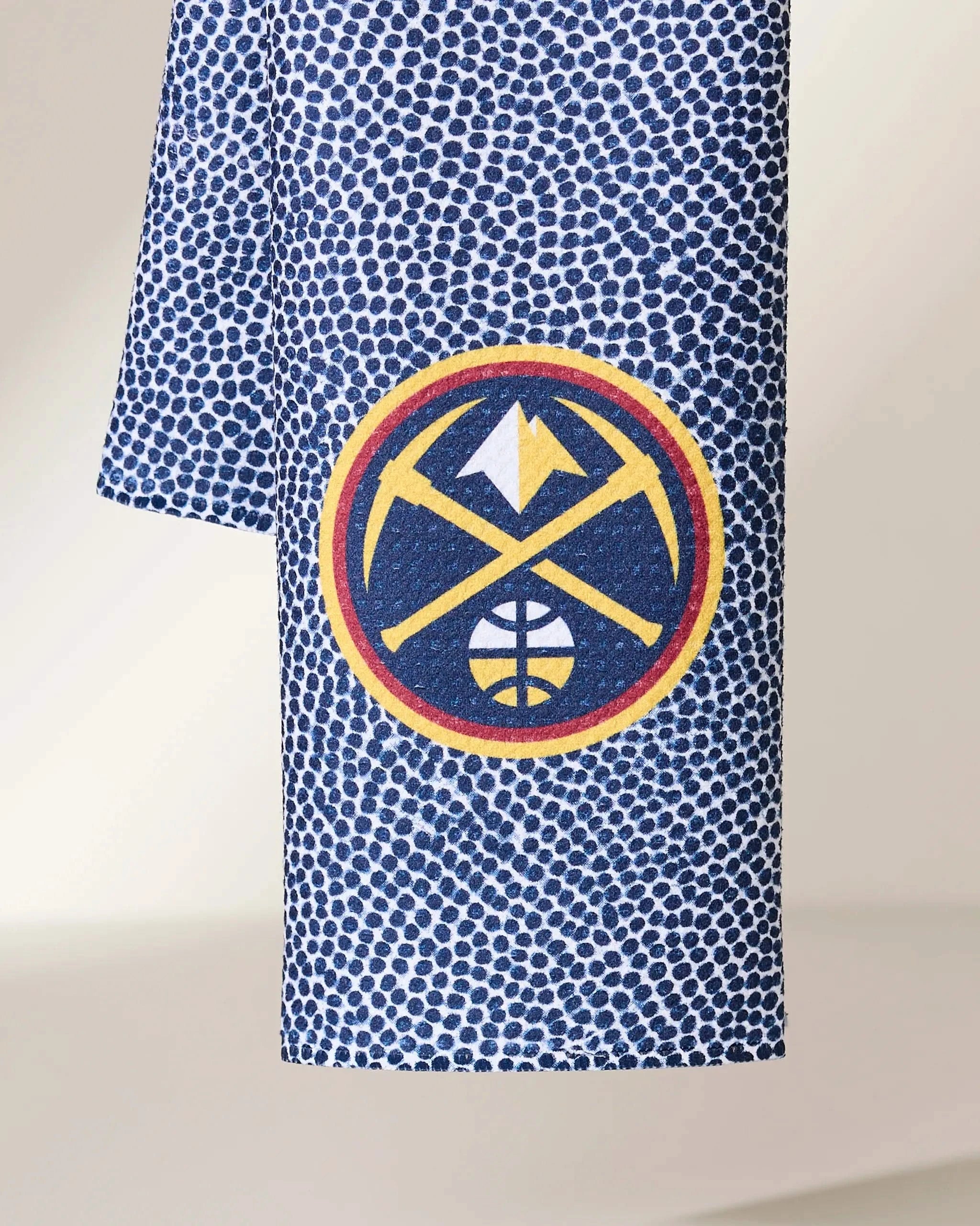 Geometrys Nuggets Grip features a blue and white speckled fabric with the Denver Nuggets logo—two crossed pickaxes, a mountain, and a basketball—set inside a red and yellow circle.
