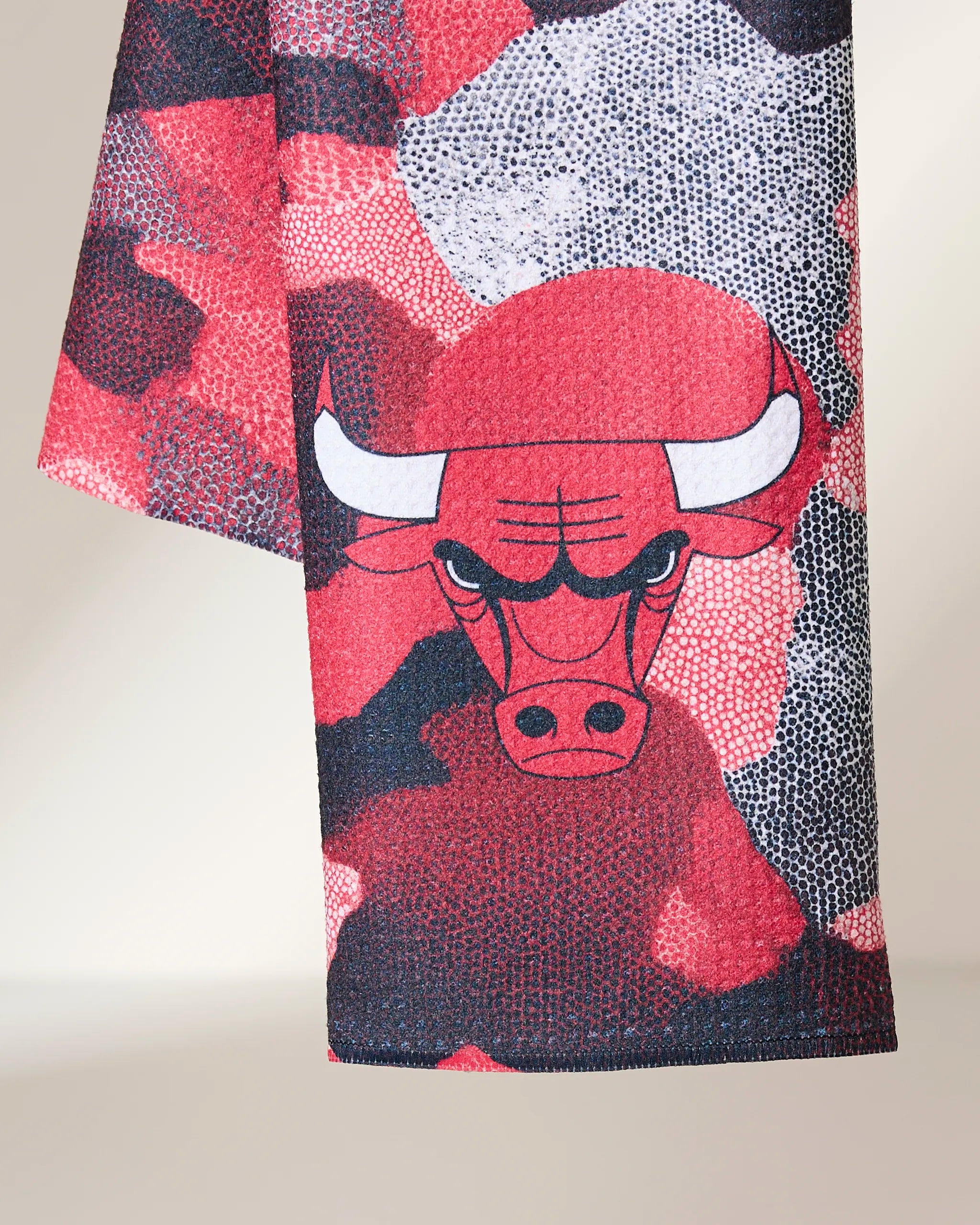 The Geometry Bulls Camo tea towel features a red, black, and white camouflage design with the fierce Chicago Bulls logo, made from quick-drying recycled materials.