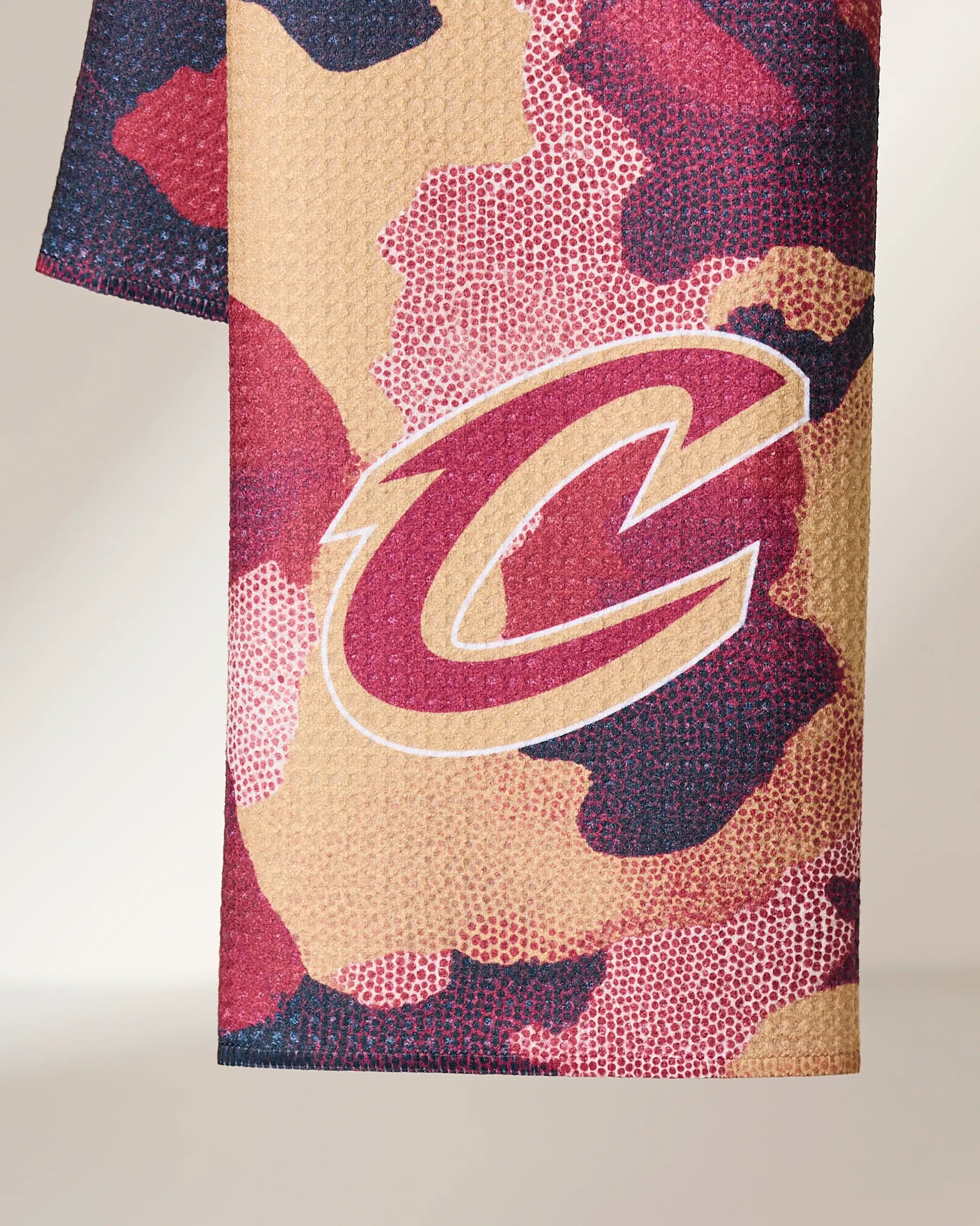 The Geometry Cavaliers Camo tea towel showcases a maroon, tan, and black camo design with a bold Cleveland Cavaliers C logo outlined in white and gold.