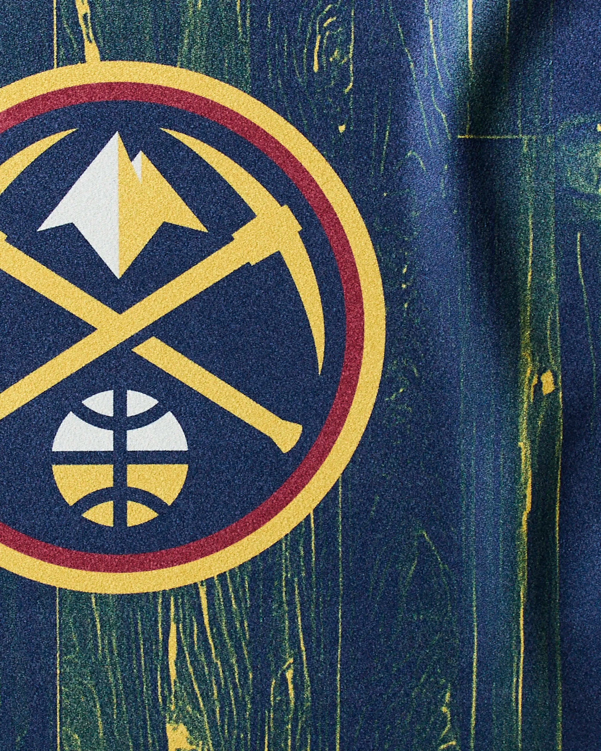 The image displays the Denver Nuggets logo with a pickaxe, mountain, and basketball on a blue-green wooden background. Nuggets Zone by Geometry is the perfect NBA fitness towel for fans to add to their workout gear.