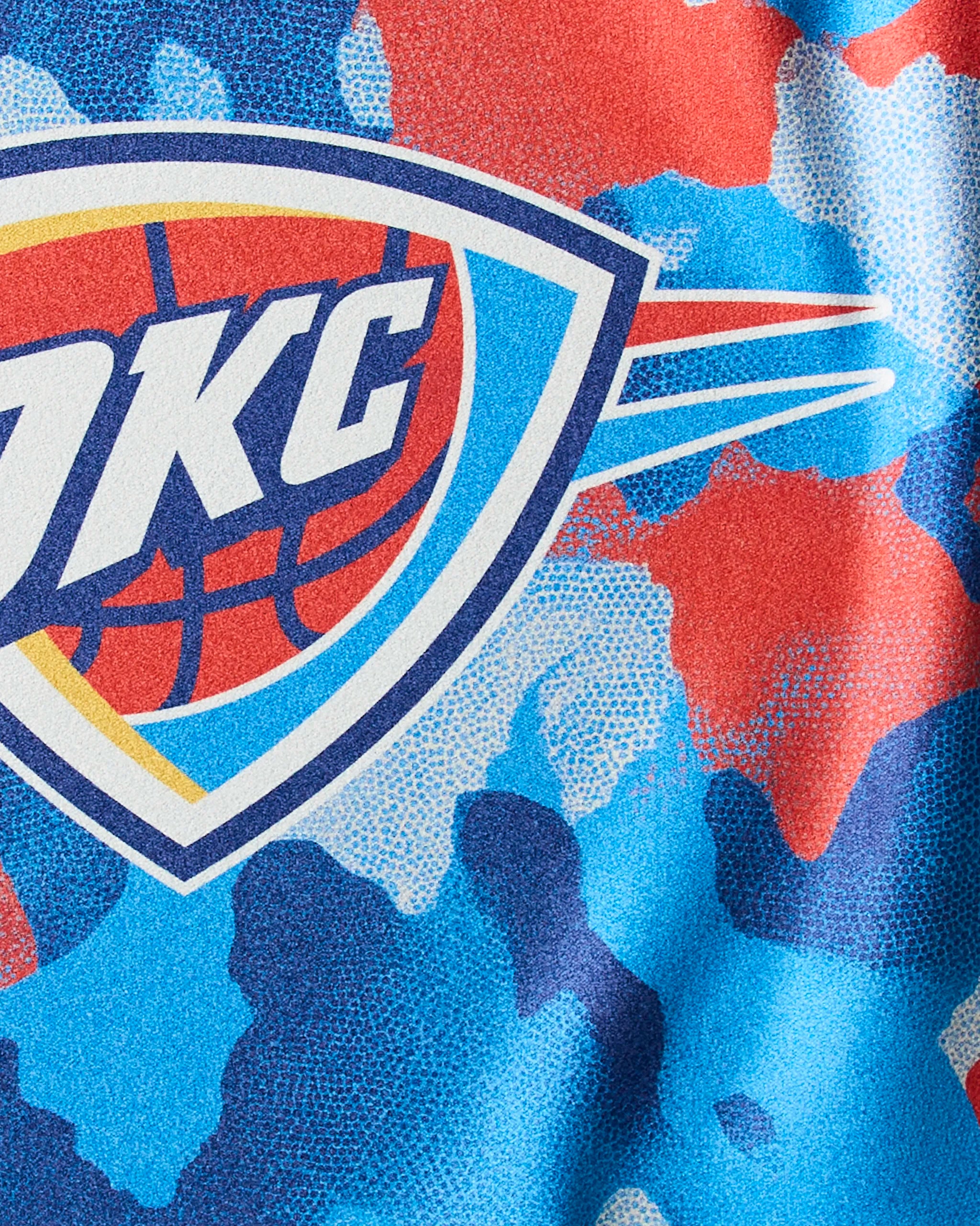 Close-up of the Geometry OKC Camo gym towel featuring the Oklahoma City Thunder logo and a blue, red, and white camouflage design.