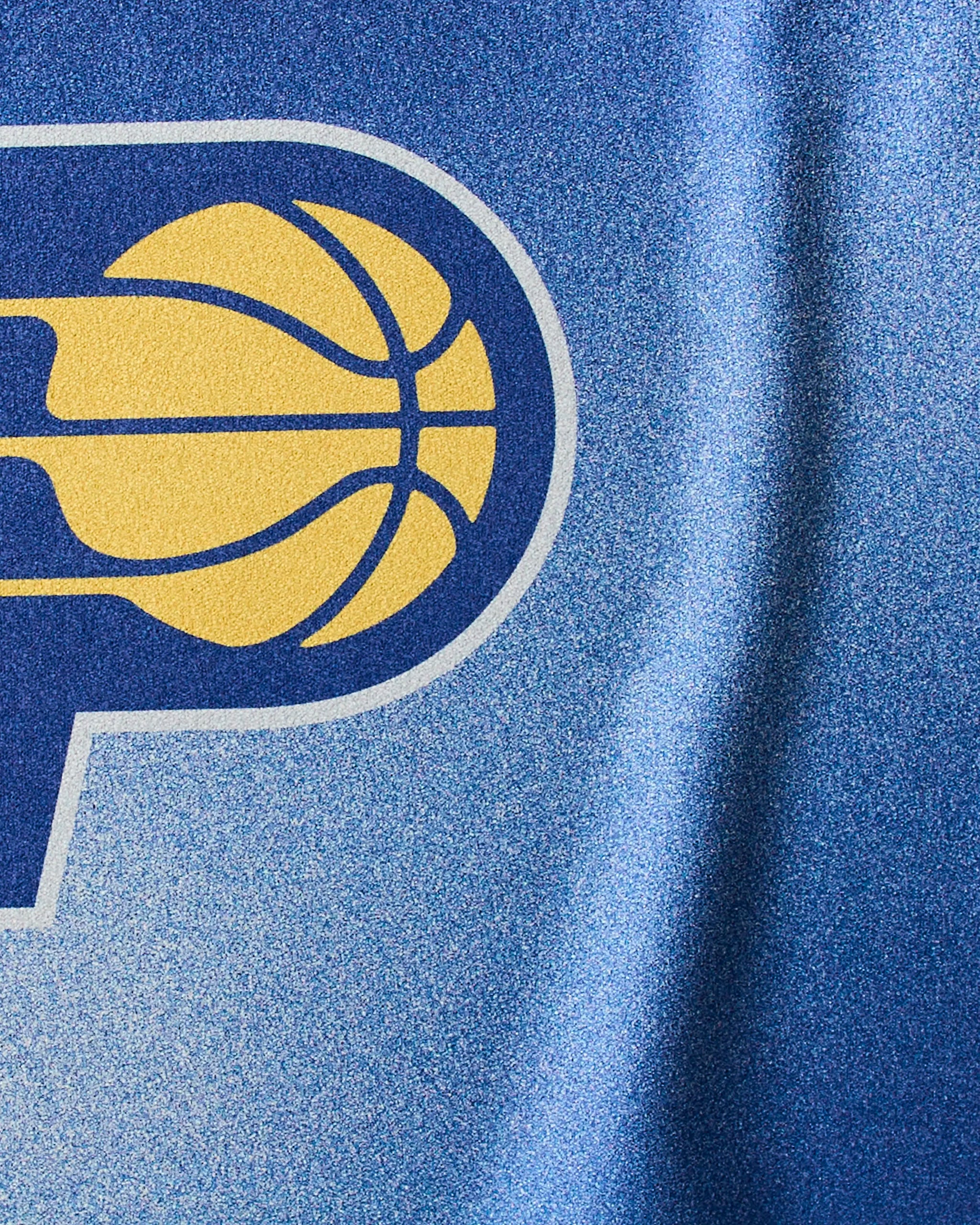 Close-up of the Geometry Pacers Fade NBA fitness towel, showing a stylized blue and yellow letter P with a basketball on textured fabric.