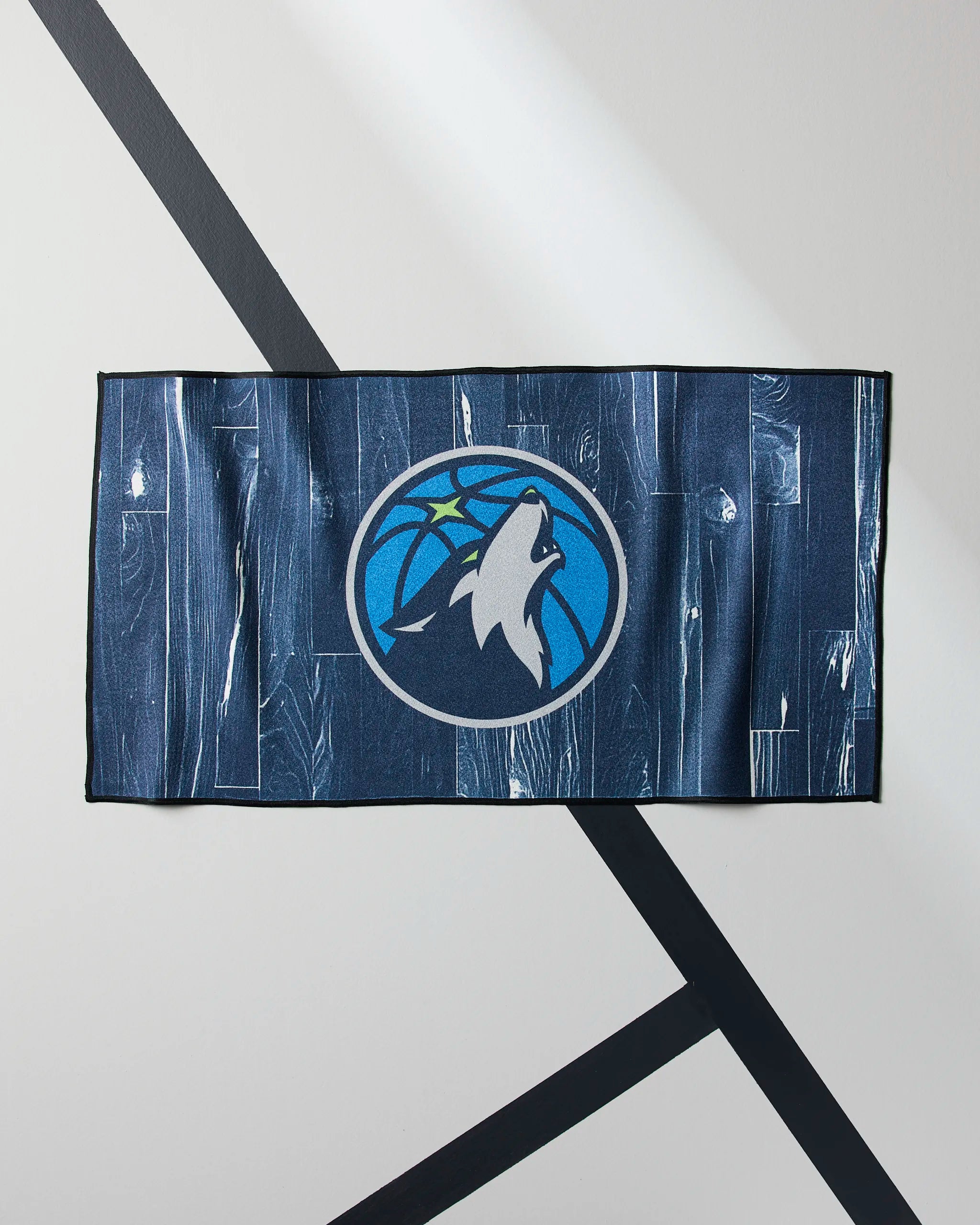 Geometry's Timberwolves Zone mat, featuring a bold Minnesota Timberwolves howling wolf and star logo, elevates your workouts—pair it with your NBA fitness towel on any light floor for a winning combo.