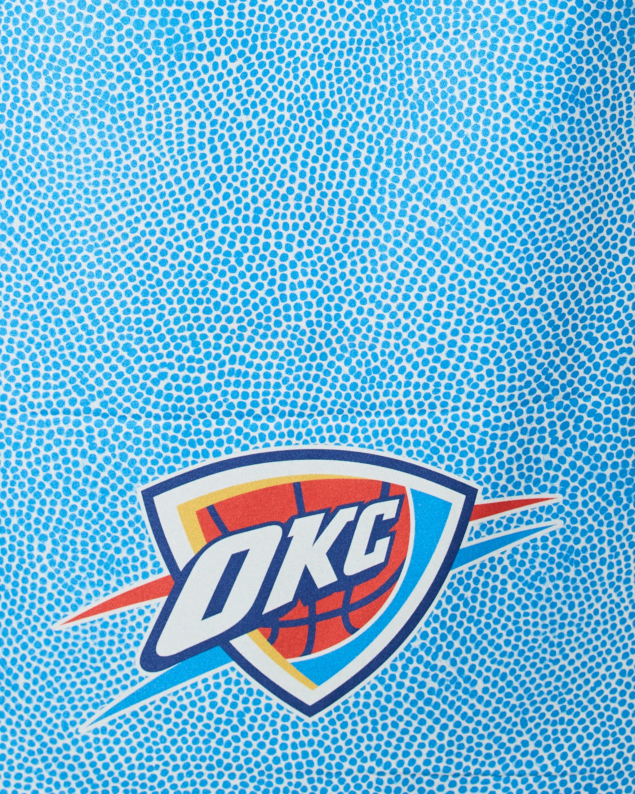 Blue textured background with the OKC Grip by Geometry, featuring the Oklahoma City Thunder basketball team logo—a basketball and shield with OKC text, stylized lines, and bold colors.