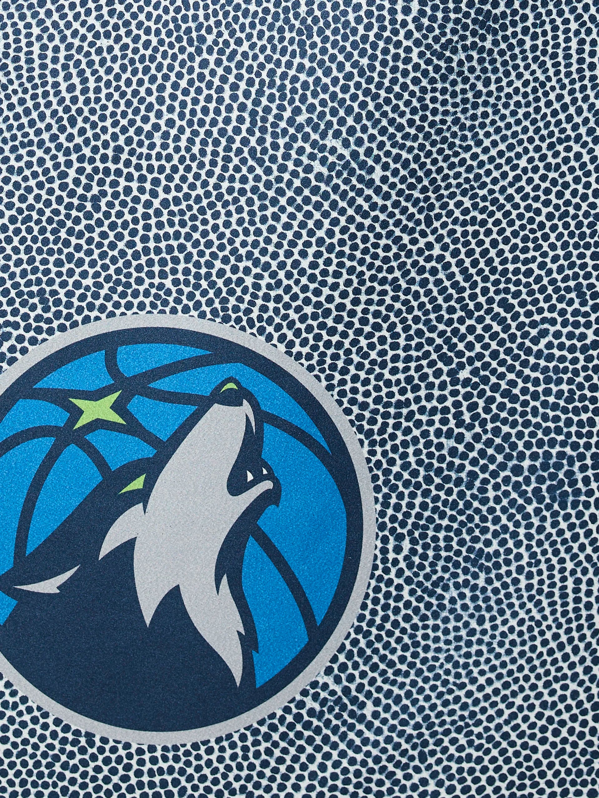 Close-up of the Timberwolves Grip by Geometry, featuring a textured basketball surface with the Minnesota Timberwolves logo—a howling wolf in front of a blue basketball and green star.