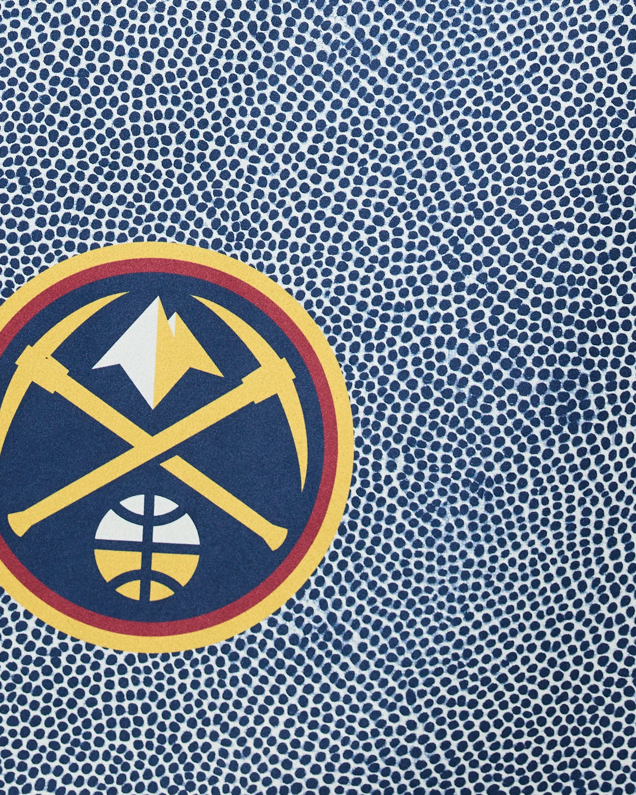 The Nuggets Grip by Geometry features the Denver Nuggets logo—two crossed pickaxes, a mountain peak, and a basketball—set on a blue, dotted background that mimics a basketball’s surface.