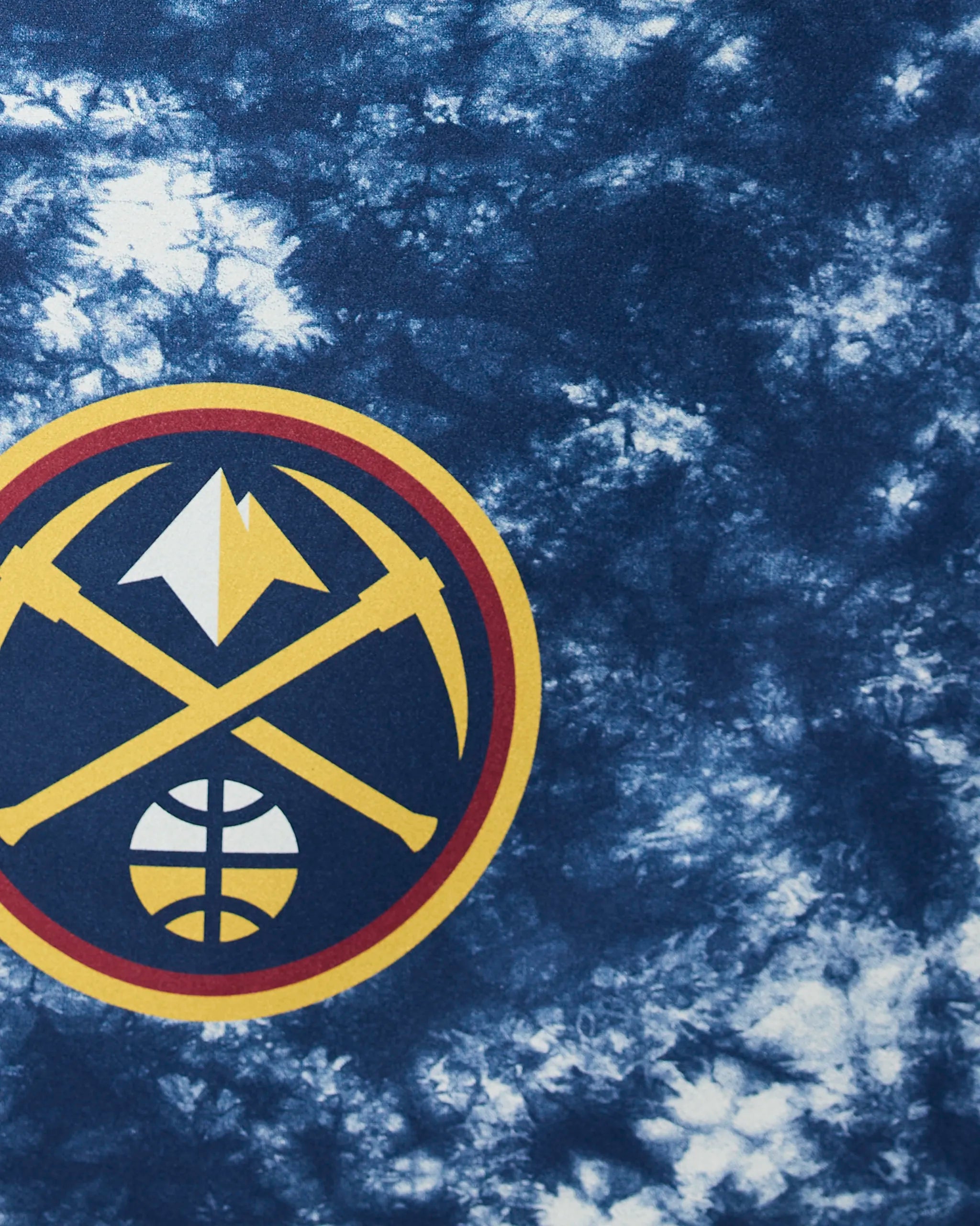 The Geometry Nuggets Flash features the Denver Nuggets logo with crossed gold pickaxes, a white mountain, and a basketball inside a circular border on a blue and white tie-dye background.