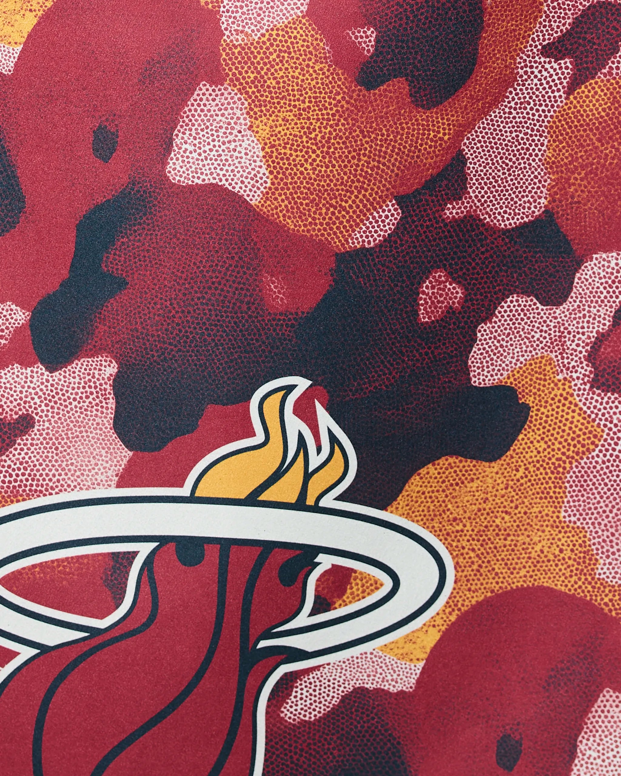 Close-up of Geometrys Heat Camo design, showcasing the Miami Heat logo with a flaming basketball on a vibrant red, orange, and black camouflage background.