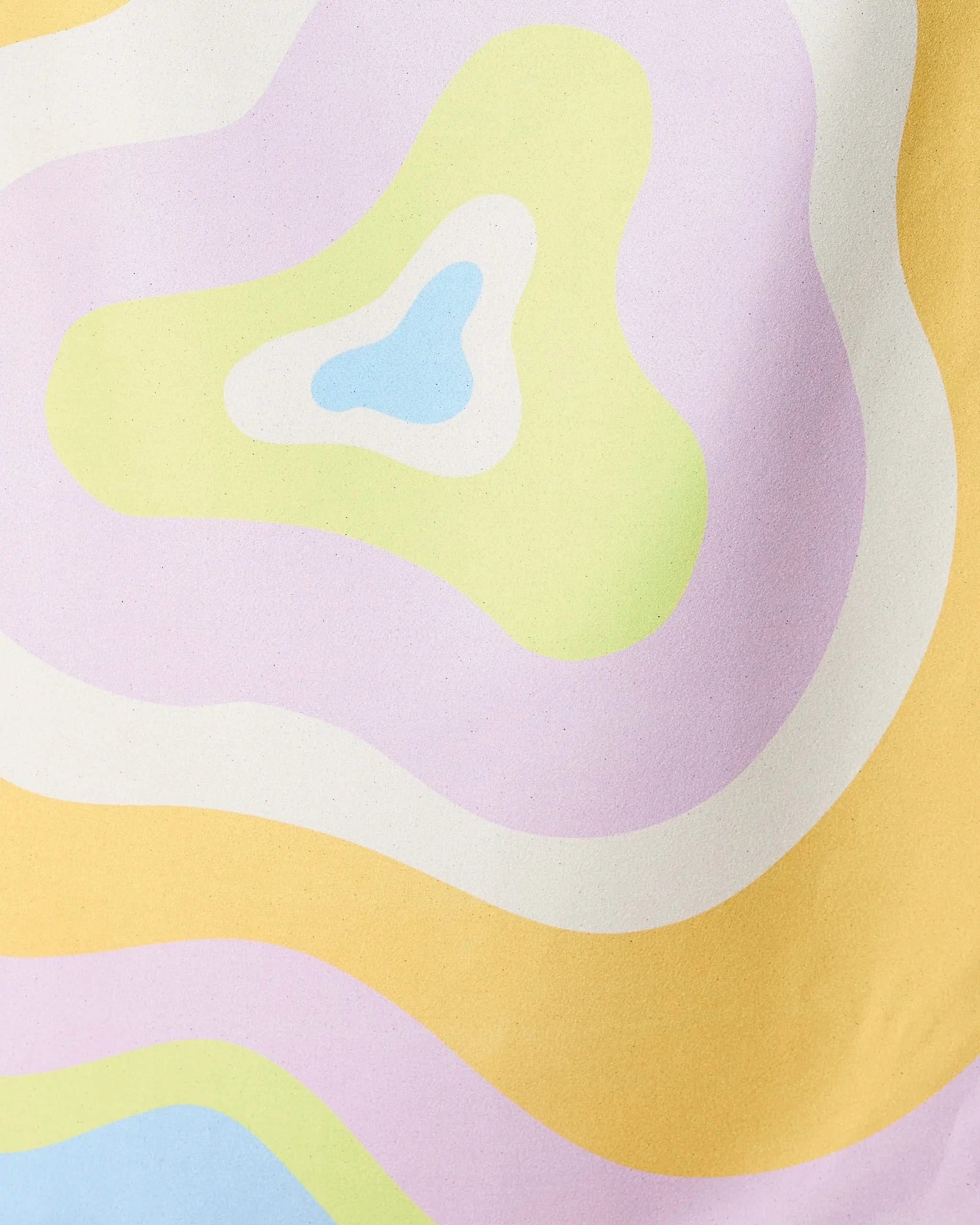 Pastel-hued, wavy shapes in yellow, lavender, green, blue, and white overlap in an abstract design—capturing the playful spirit of GEOMETRY’s Swirls Micro-loop Beach Towel.