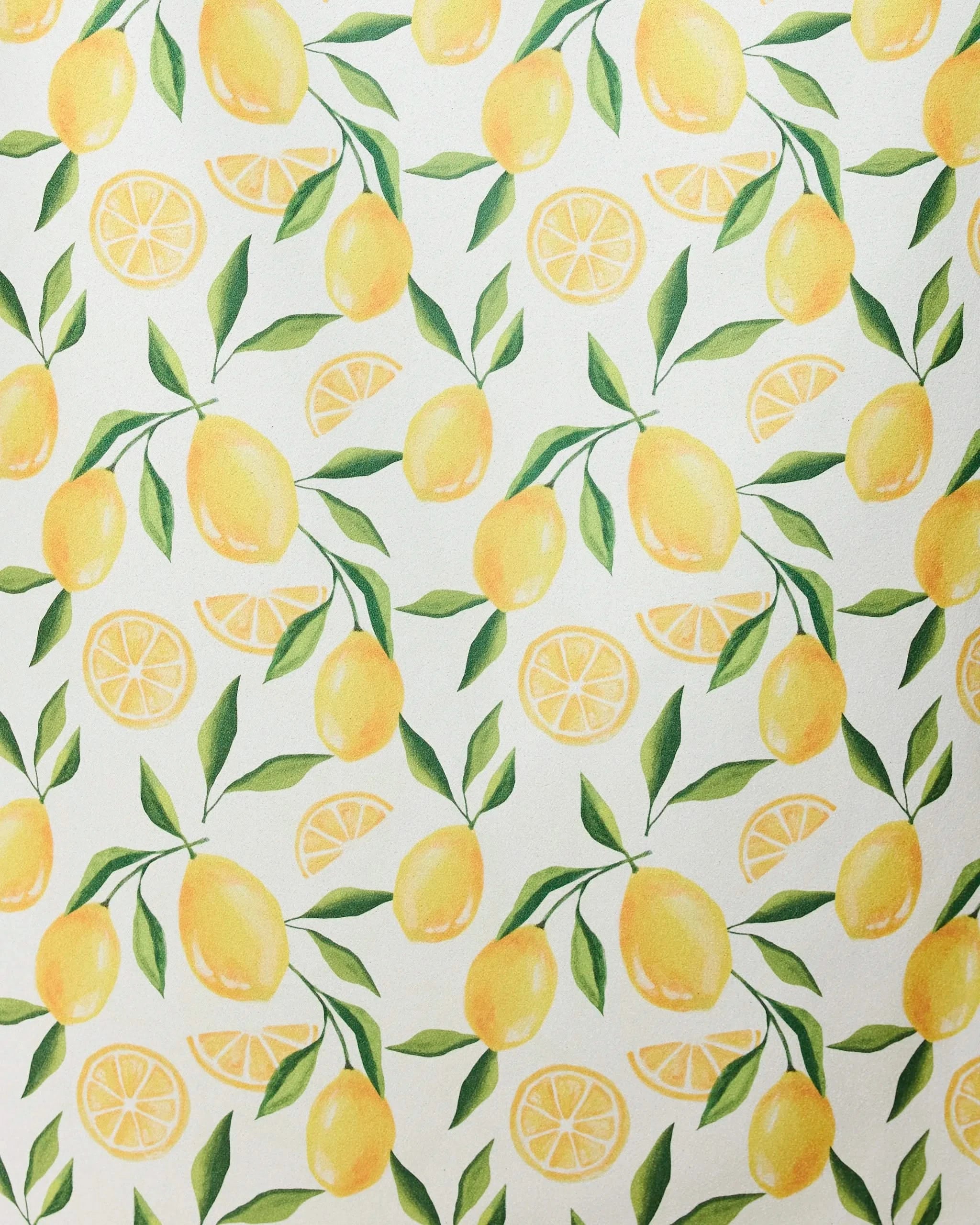The Limoncello micro-loop beach towel by GEOMETRY features a seamless pattern of whole yellow lemons, lemon slices, and green leaves on white—crafted from recycled materials for a fresh, summery style.