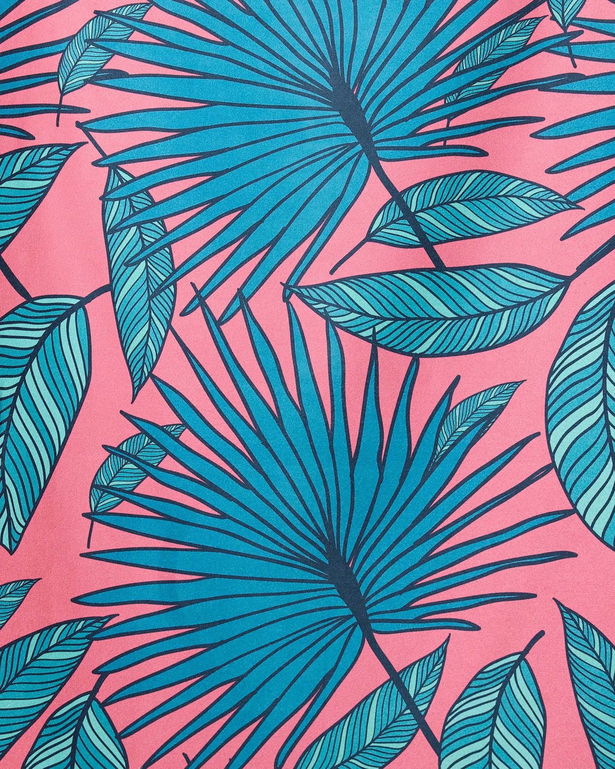 The GEOMETRY Jazzy Jungle Micro-loop beach towel features blue palm and green striped leaves on a pink background, creating a vibrant tropical pattern with quick-drying fabric.