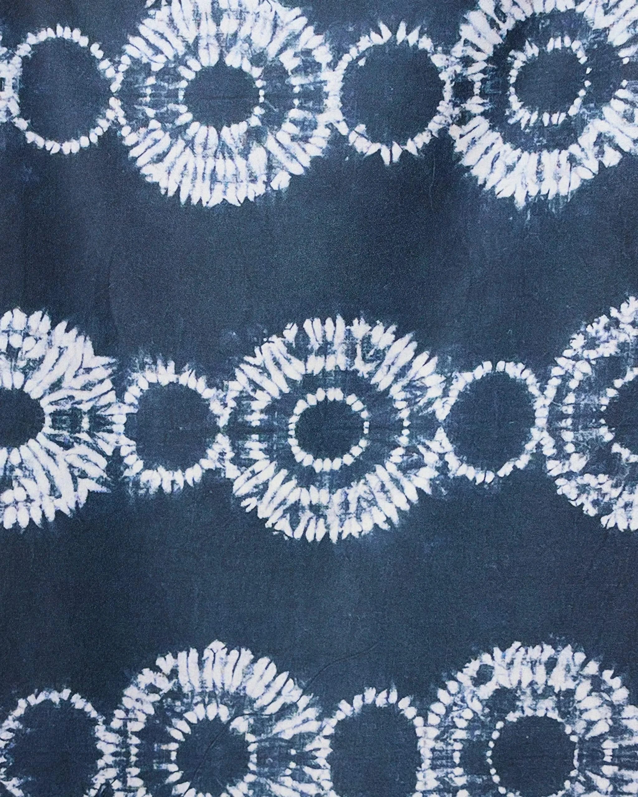 The GEOMETRY Shibo Stars micro-loop beach towel features abstract dark blue fabric with interconnected white tie-dye circles in horizontal rows, creating a striking geometric design that’s quick-drying and perfect for the beach.