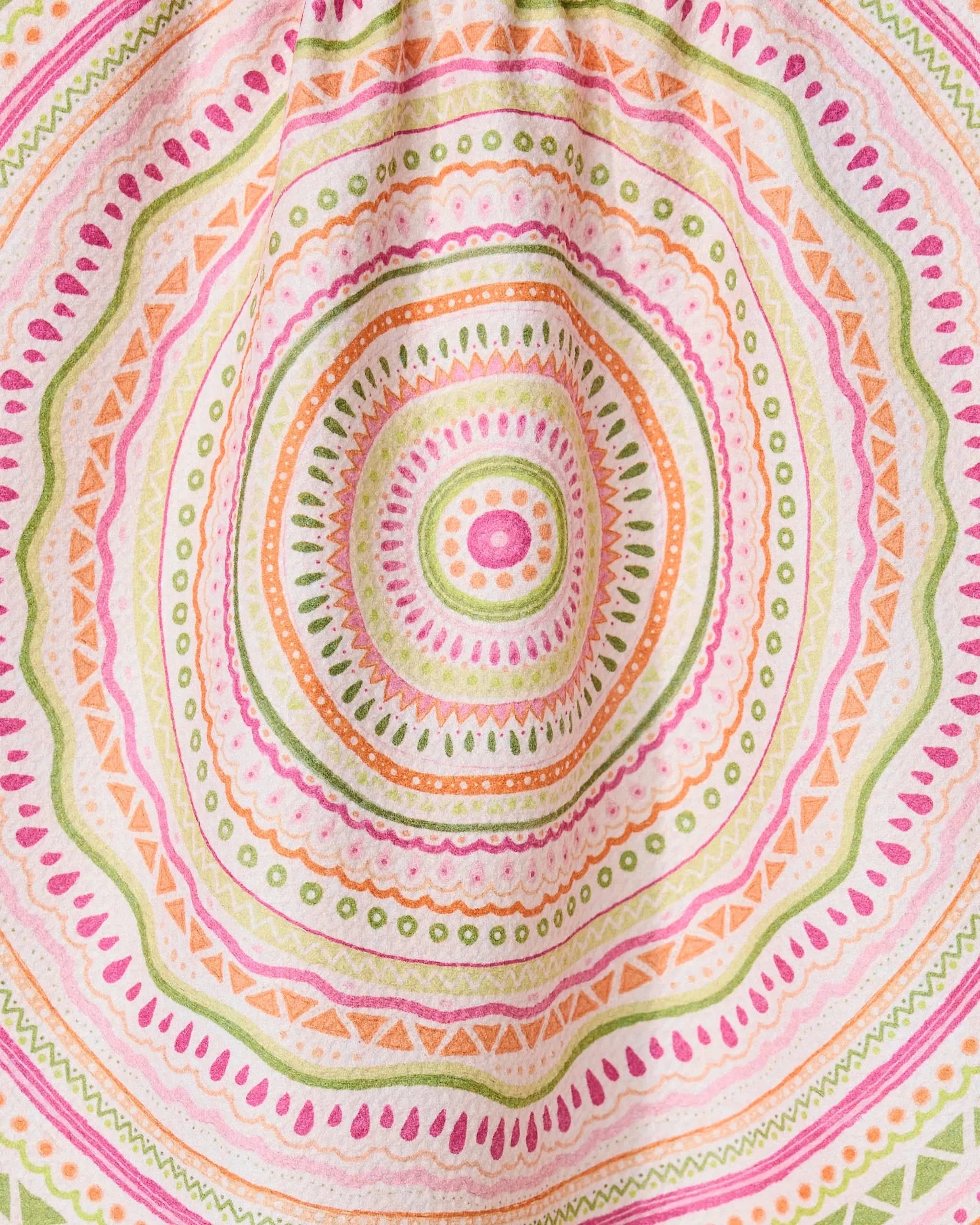 Bohemian Spring by GEOMETRY features a colorful mandala pattern with concentric circles and geometric shapes in pink, orange, green, and yellow on a quick-drying tea towel made from recycled materials.