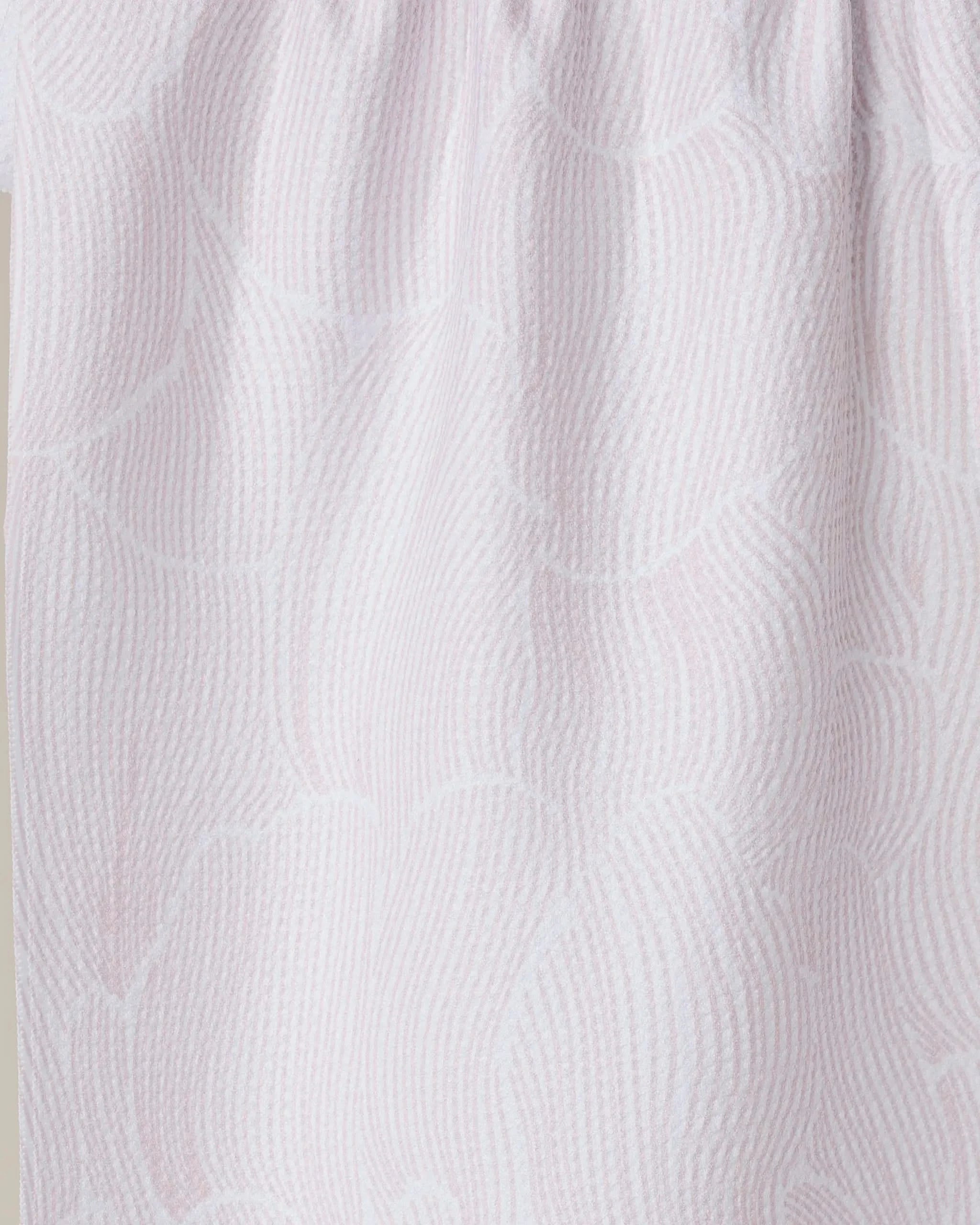Close-up of the Geometry Posh Petals Blushed Bergamot tea towel, featuring a light pink and white wavy textured pattern with gathered folds, crafted from recycled materials.
