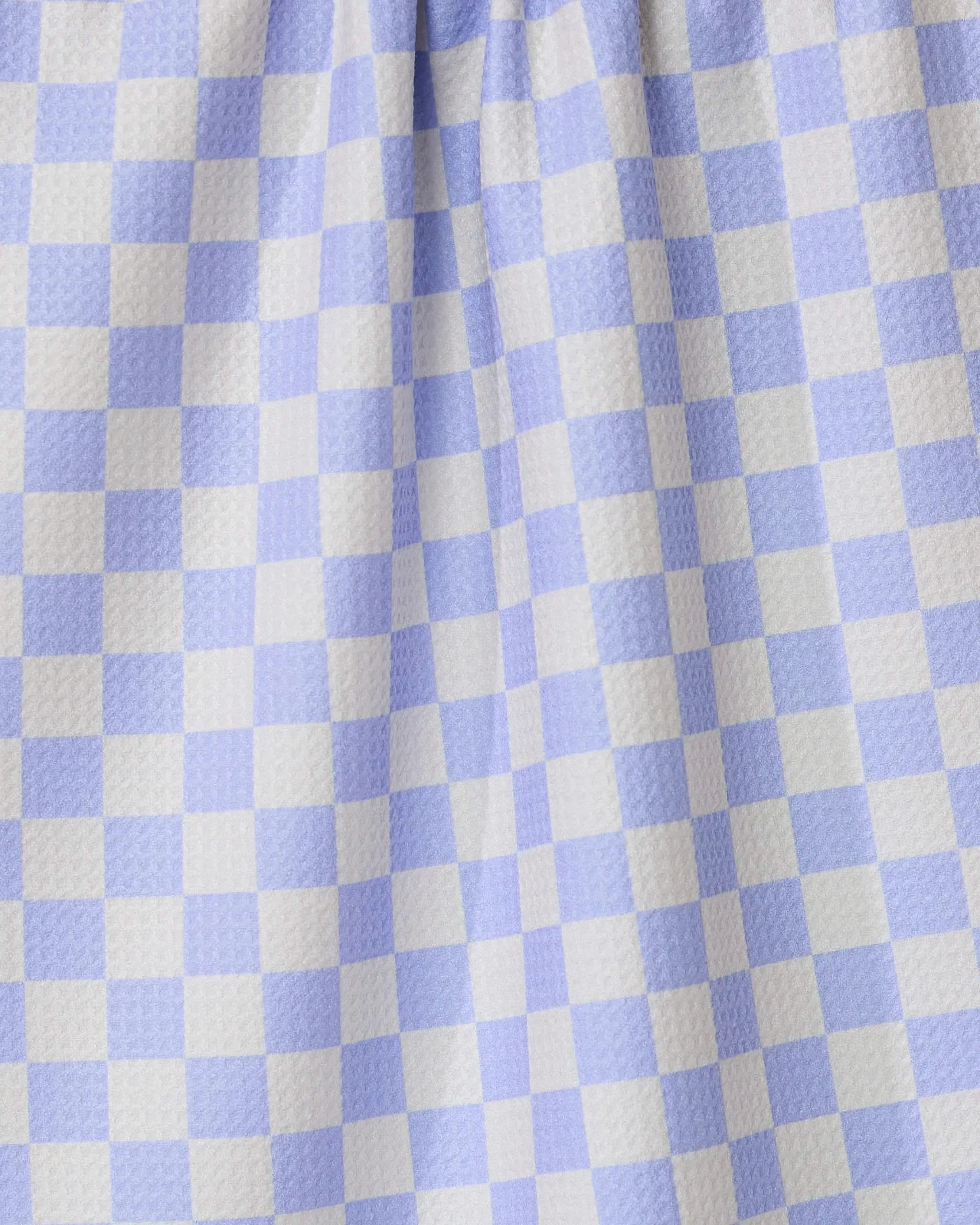 Close-up of Purple Picnic by GEOMETRY, featuring purple and white gingham checkered fabric with a textured surface and gentle folds—perfect for an ultra-absorbent tea towel in any kitchen.