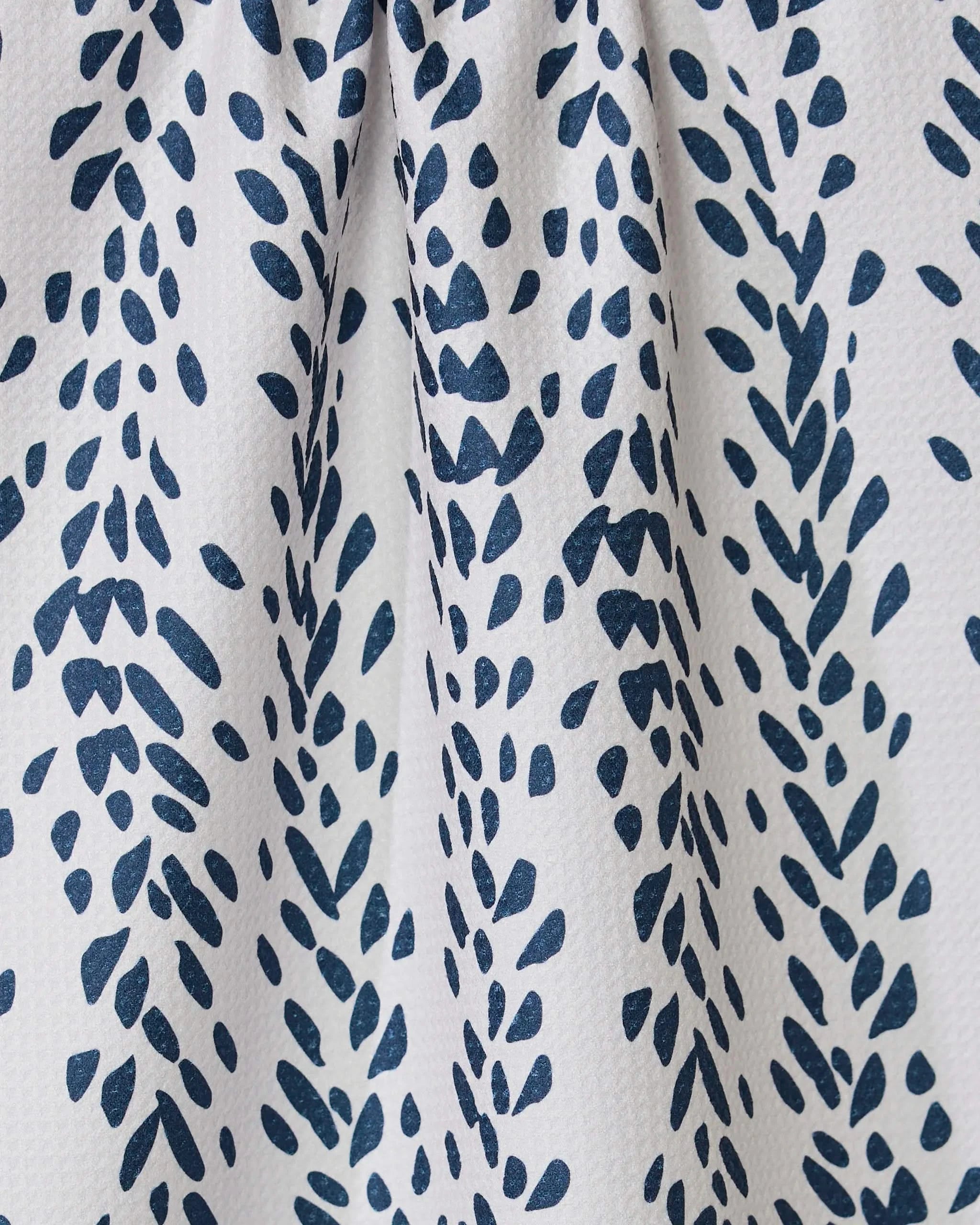 The Reeds Printed - Midnight tea towel by GEOMETRY features ultra-absorbent white fabric with a geometric, navy leaf-like pattern and elegant texture—perfect as a stylish addition to any kitchen.