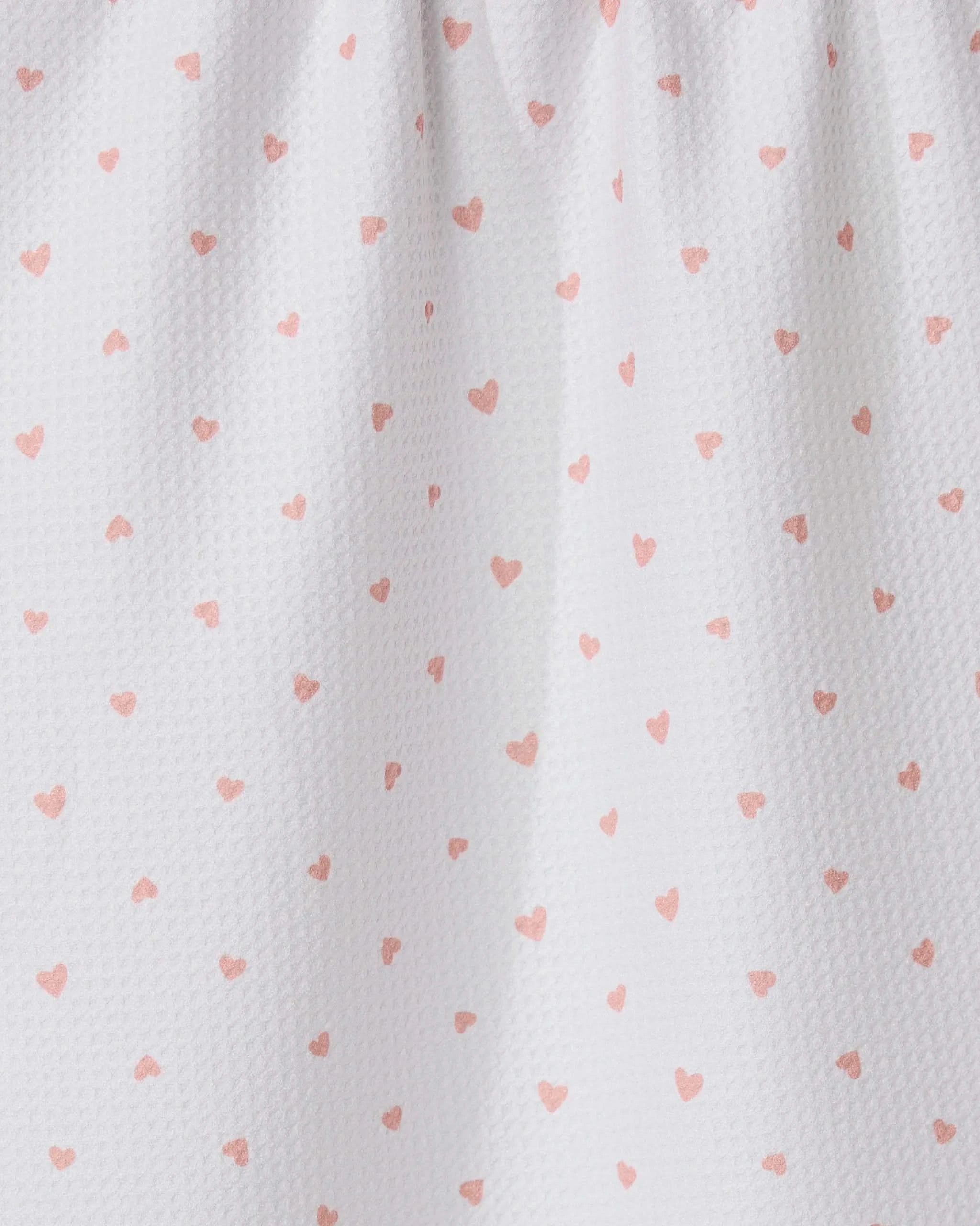 The GEOMETRY Tiny Hearts tea towel features ultra-absorbent white fabric with small pink heart patterns and a gathered top for soft folds and shadows.