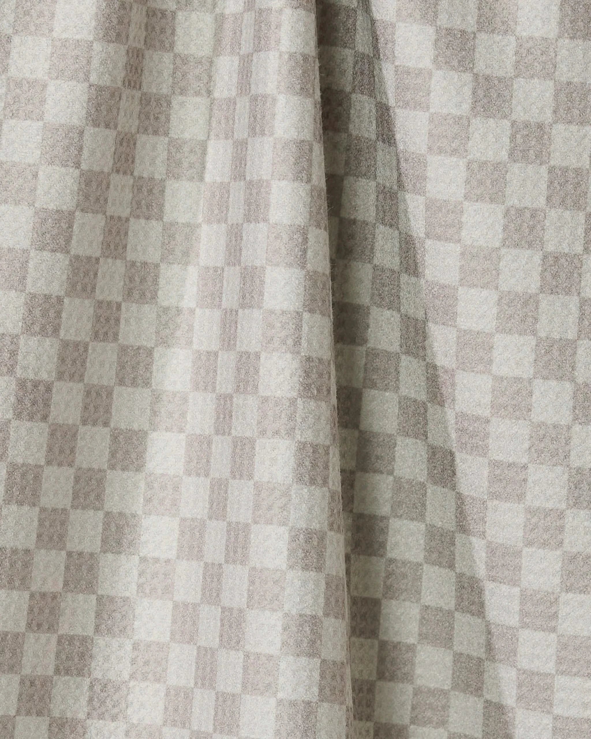 Flamingo Dance by Geometry features light beige and cream checkered drapes made from recycled kitchen towels, with a visible center fold that casts soft shadows and highlights the textured look of the small, even squares.