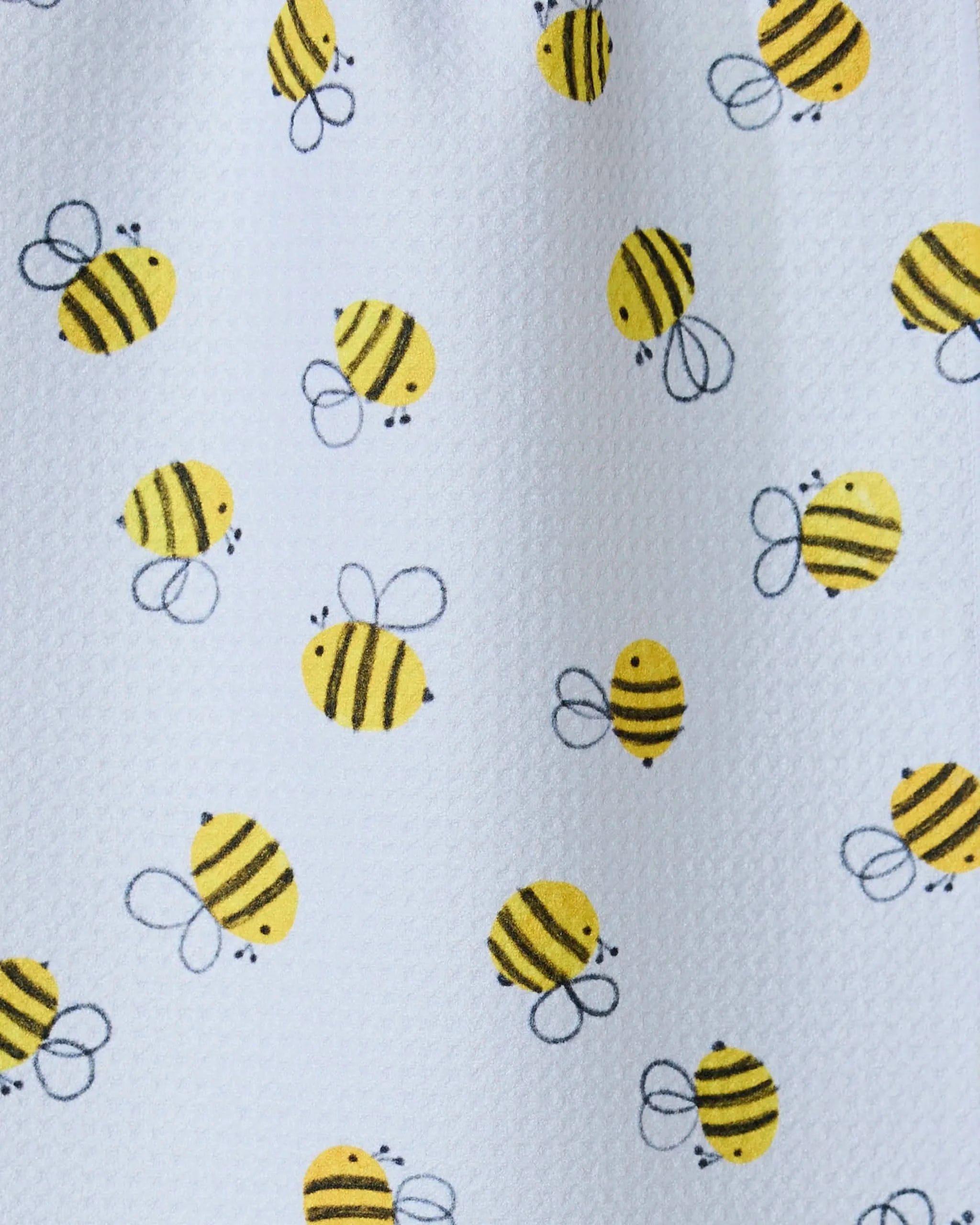 Buzzing by GEOMETRY features a playful pattern of cartoon yellow bees on a white textured background, ideal for an ultra-absorbent towel or bar towel crafted from recycled materials.