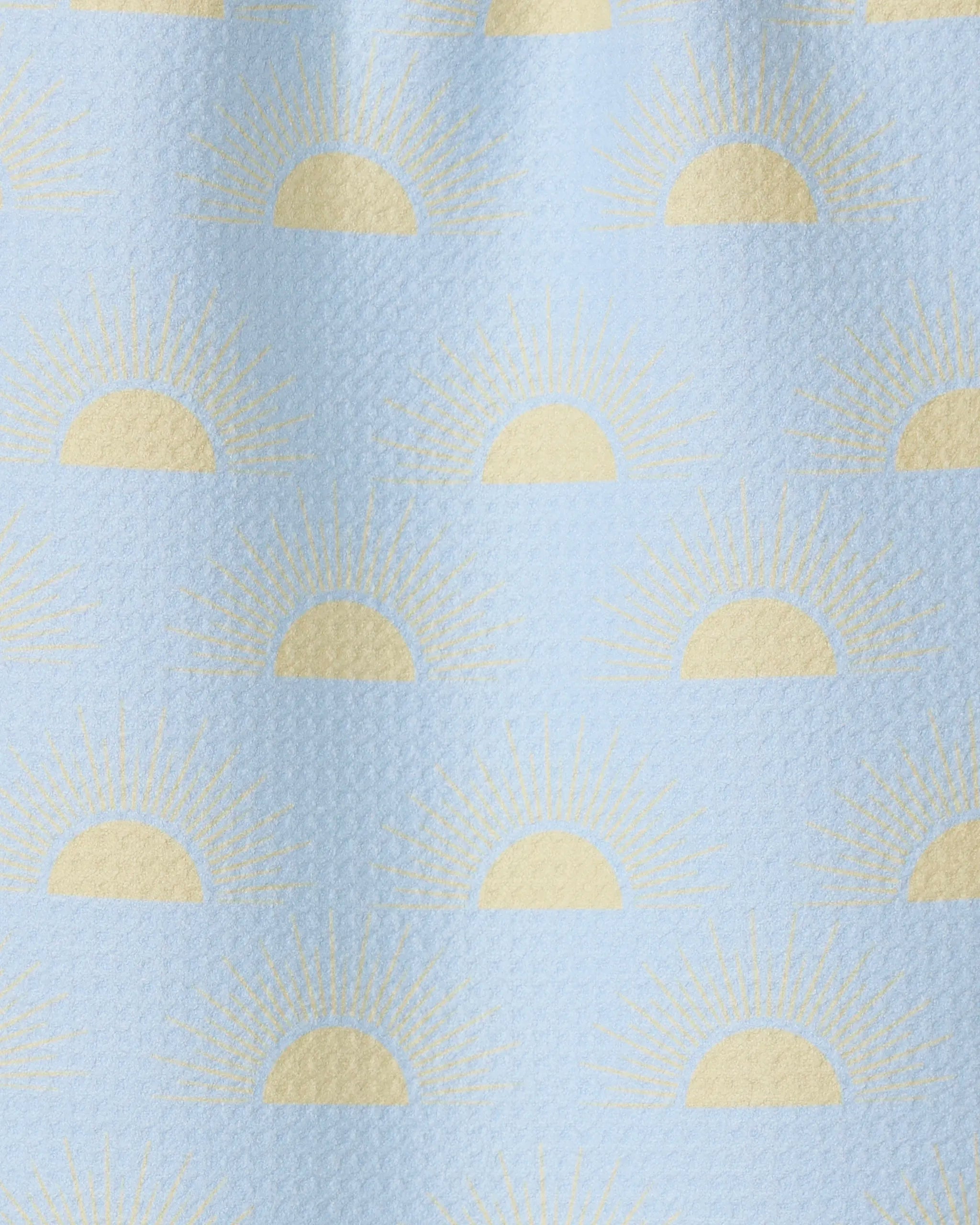 Soft Summer Sun by GEOMETRY is a light blue textured fabric made from recycled materials, featuring yellow half-sun sunrise motifs and radiating rays in an evenly spaced, repeating pattern.