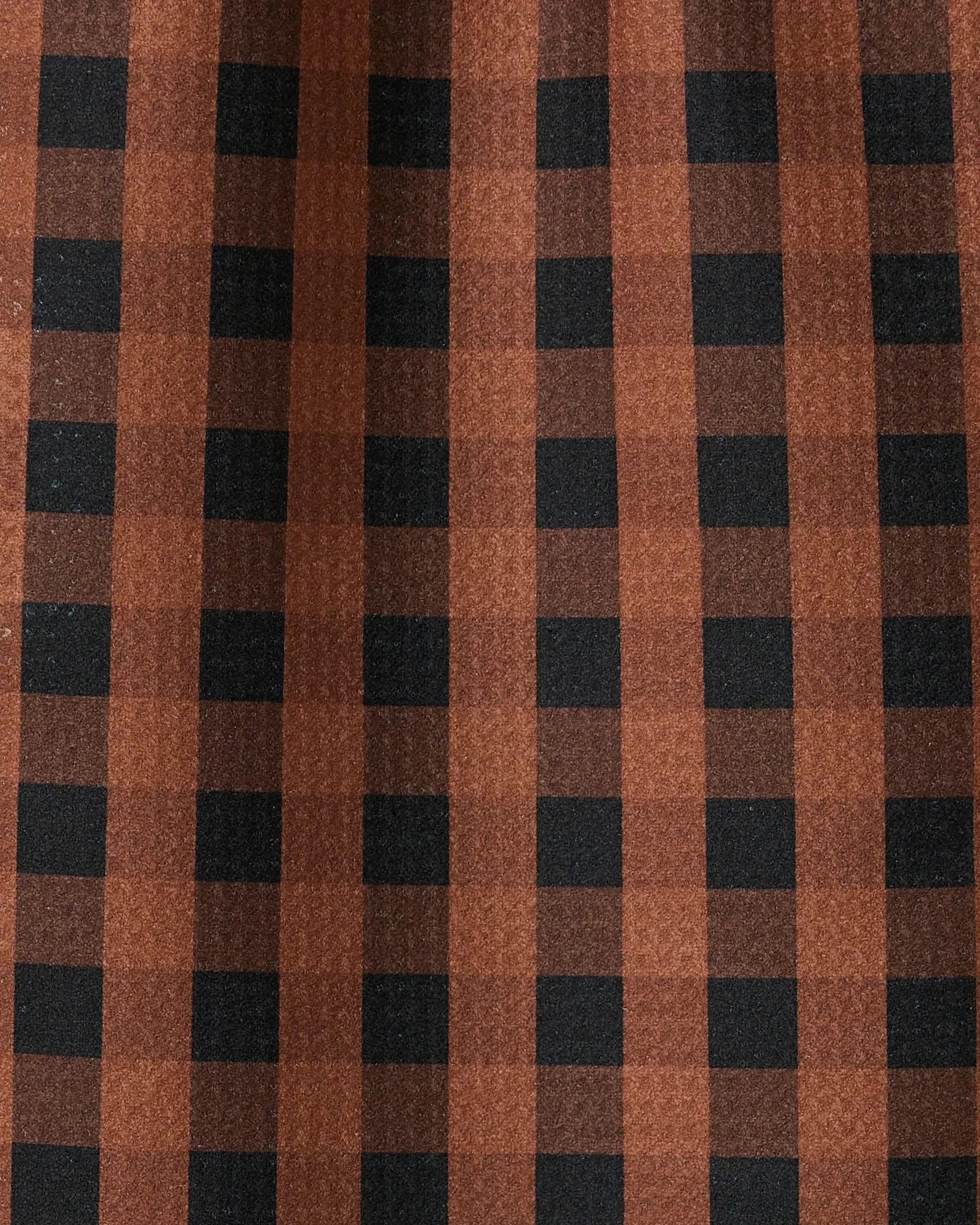 Close-up of GEOMETRYs Fall Gingham bar towel, featuring a brown and black checkered pattern. The ultra-absorbent fabric has gentle folds and subtle shadows, with vertical and horizontal stripes forming classic squares.